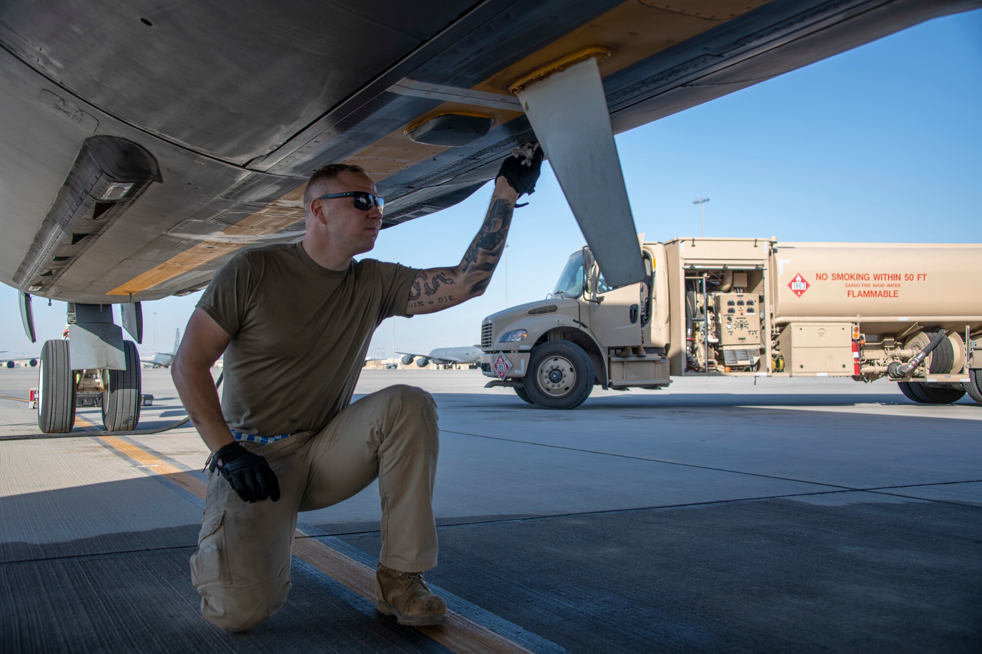 A maintenance Airman checks the fuselage of an aircraft.