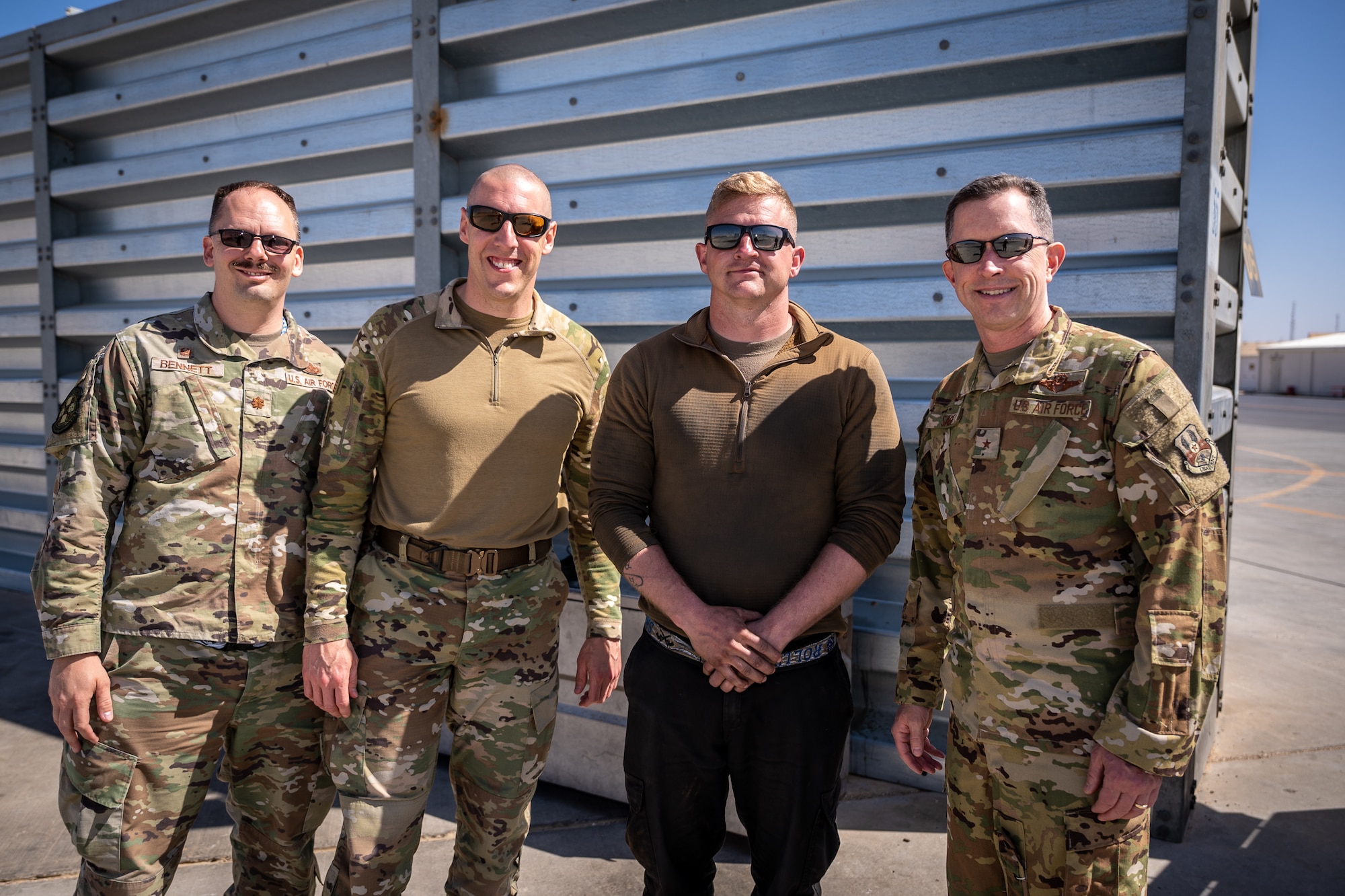 Staff Sgt. Corey McWhorter, 55th Expeditionary Fighter Generation Squadron engine technician and multi-capable airman team (MCAT) member, stands with Maj. Christopher Bennett, 55th EFGS commander, Chief Master Sgt. Sean Milligan, 332nd Air Expeditionary Wing command chief, and Brig. Gen. Christopher Sage, 332d AEW commander, at an undisclosed location in Southwest Asia, April 9, 2022. McWhorter was recognized for stepping out of his primary air force job and filling in as a crew chief helping to launch and recover aircraft resulting in 10 successful missions. (U.S. Air Force photo by Master Sgt. Christopher Parr)
