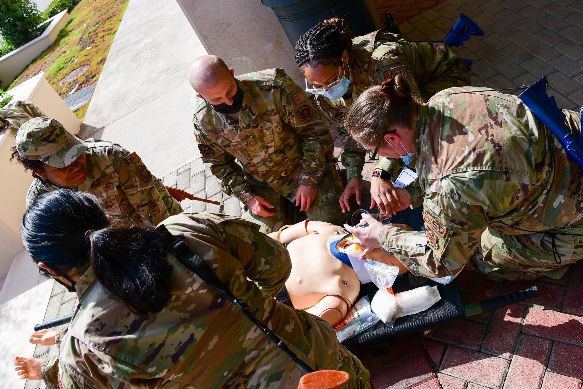U.S. Air Force Airmen from the 31st Medical Group ‘treat’ a medical mannequin for simulated wounds during a ‘trauma care under fire’ training at Aviano Air Base, Italy, April 12, 2022. For the first time at Aviano AB, approximately 40 31st MDG  technicians conducted joint ‘trauma care under fire’ training with the 31st SFS Military Working Dog K-9 unit. (U.S. Air Force photo by Senior Airman Brooke Moeder)