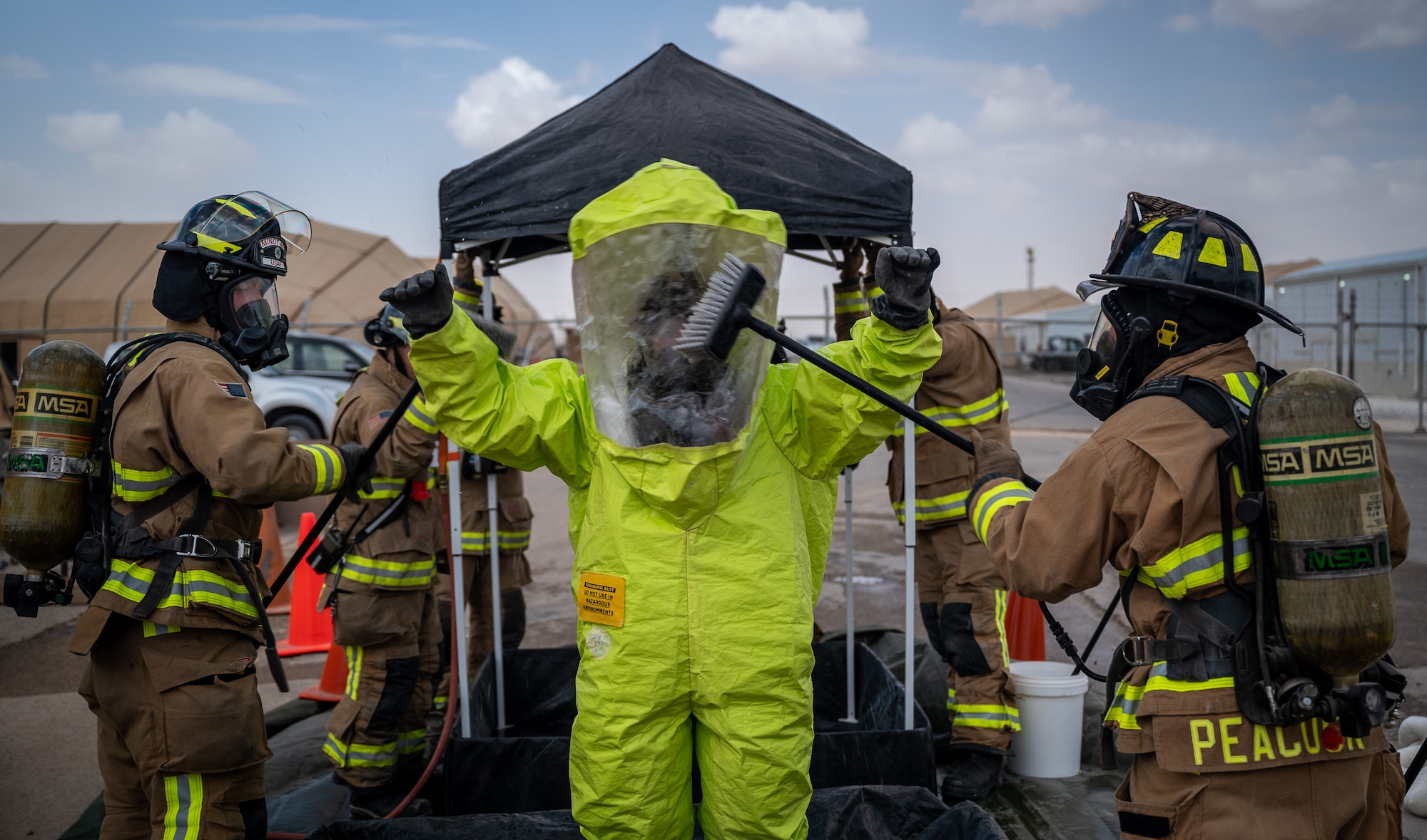 Senior Airman Katrina Brzeskiewicz, 332d Expeditionary Civil Engineer Squadron firefighter, goes through a decontamination processing line during a hazardous material exercise at an undisclosed location in Southwest Asia March 24, 2022. Ensuring any potentially hazardous material is removed helps to keep the clean area, cold zone, free of contamination. (U.S. Air Force photo by Master Sgt. Christopher Parr)