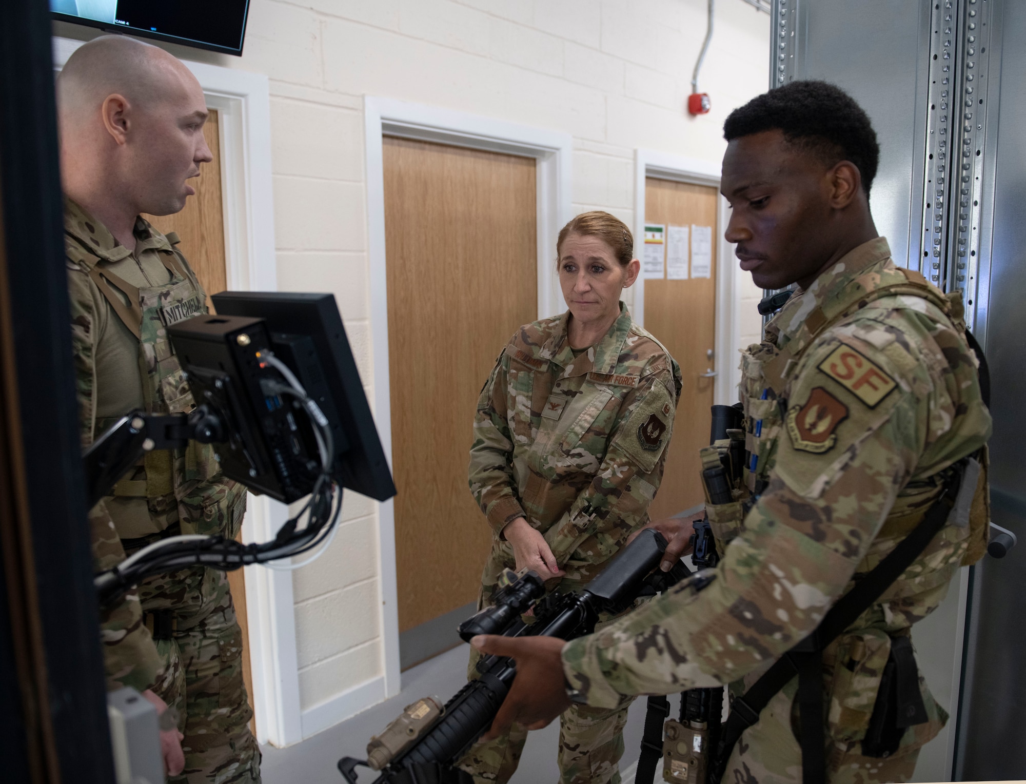 U.S. Air Force Staff Sgt. Kevin Mitchell, 422d Security Forces Squadron (SFS) non-commissioned officer in charge of the armory, left, and Airman 1st Class Daniel Nwaobi, 422d SFS security response team member, demonstrate the new radio-frequency identification weapon tracking system for Col. Lisa Wildman, 501st Combat Support Wing vice commander, at RAF Croughton, England, April 6, 2022. The armory was the first in the entire Air Force to fully integrate a RFID tracking system. (U.S. Air Force photo by Senior Airman Jason W. Cochran)