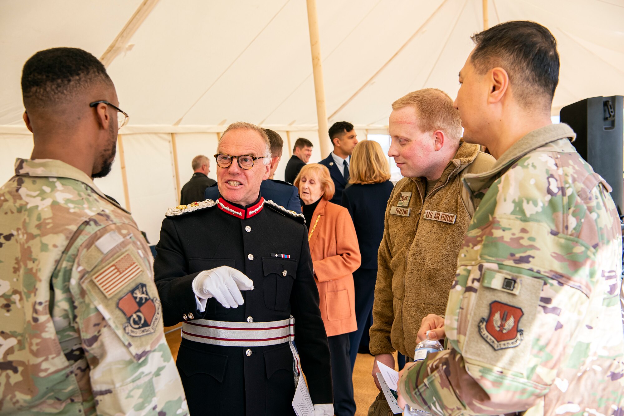 James Saunders-Watson, center, Lord-Lieutenant of Northamptonshire, speaks with Airmen from the 501st Combat Support Wing prior to the Queen’s Green Canopy event at RAF Croughton, England, Apr. 13, 2022. The event celebrated the Queen’s Platinum Jubilee initiative, marking the 70th year of her reign. During the event, trees were planted to create a legacy in honor of the queen’s leadership of the nation. (U.S. Air Force photo by Staff Sgt. Eugene Oliver)