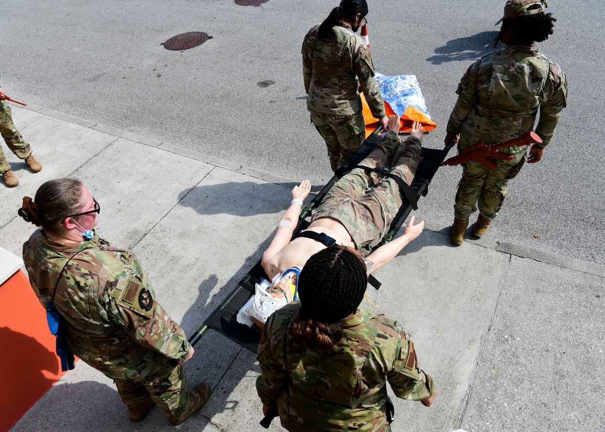U.S. Air Force Airmen from the 31st Medical Group carry a medical mannequin with simulated head trauma at Aviano Air Base, Italy, April 12, 2022. The training simulated an individual with head trauma and seizures. The team treated the patient using a 9-line method and called in a medevac. During this process, the team gave a representative a standardized 9-point description of what's going on. (U.S. Air Force photo by Senior Airman Brooke Moeder)