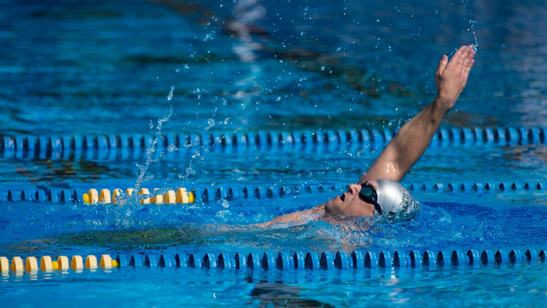 An RSM works on his backstroke during swimming practice.