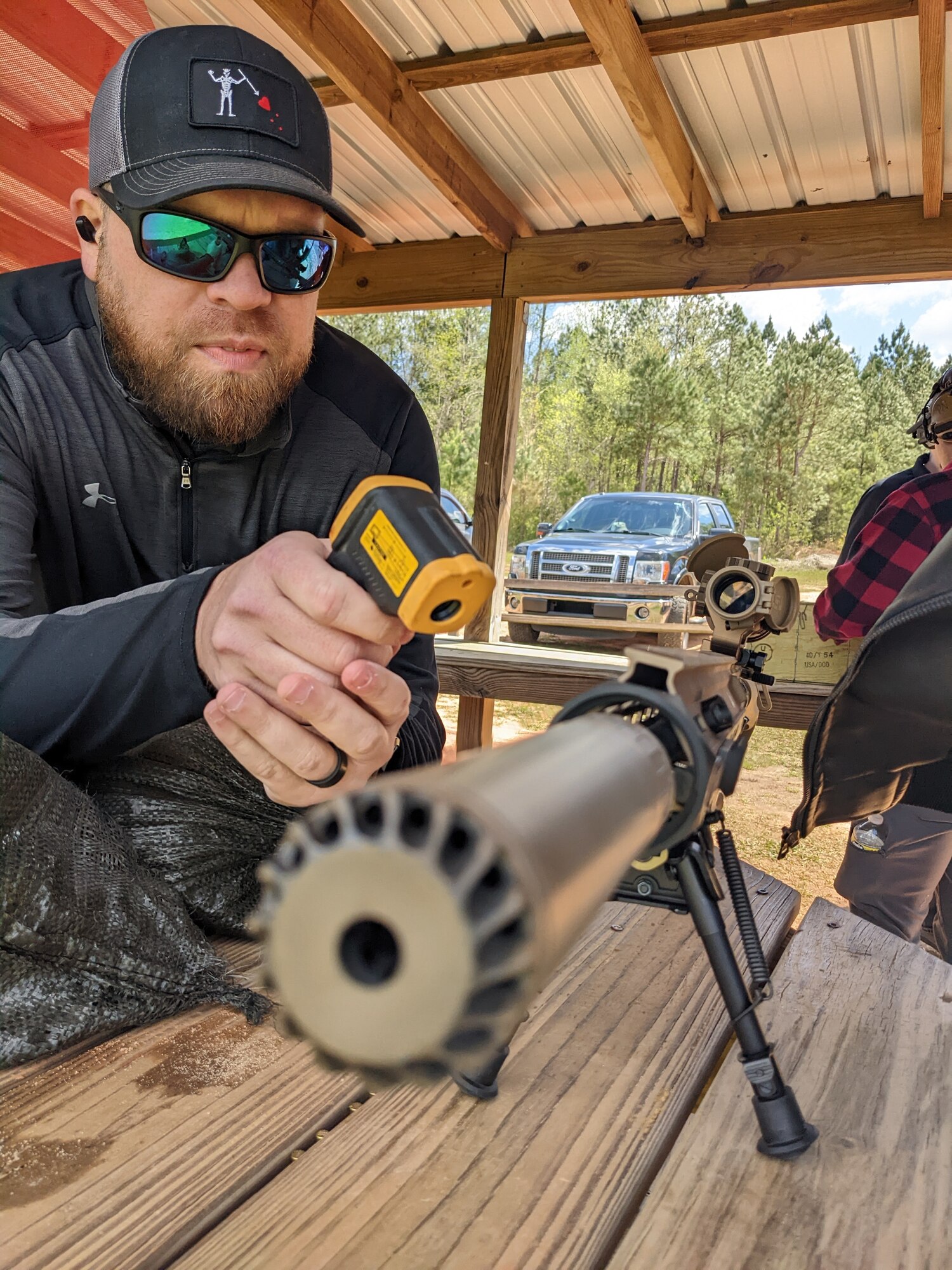 Michael Hart, the lead Small Arms Engineer is checking the Squad Designated Marksmanship Rifle's suppressor (often referred to as a “can”) external temperature after firing an Army basic combat load of 120 rounds.  Cans get hot the more rounds and the faster you shoot through them.  Michael checked the external and internal temps after each series of rounds.  (U.S. Air Force photo/Shaun Ferguson)