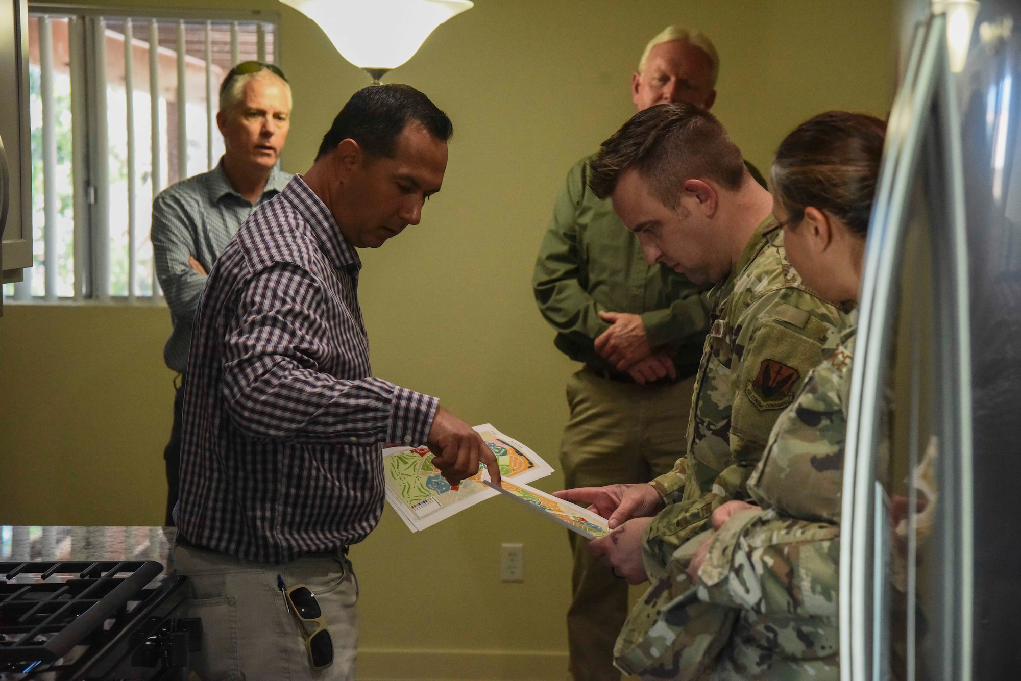 A photo of a man showing the layout of a home to Airmen.