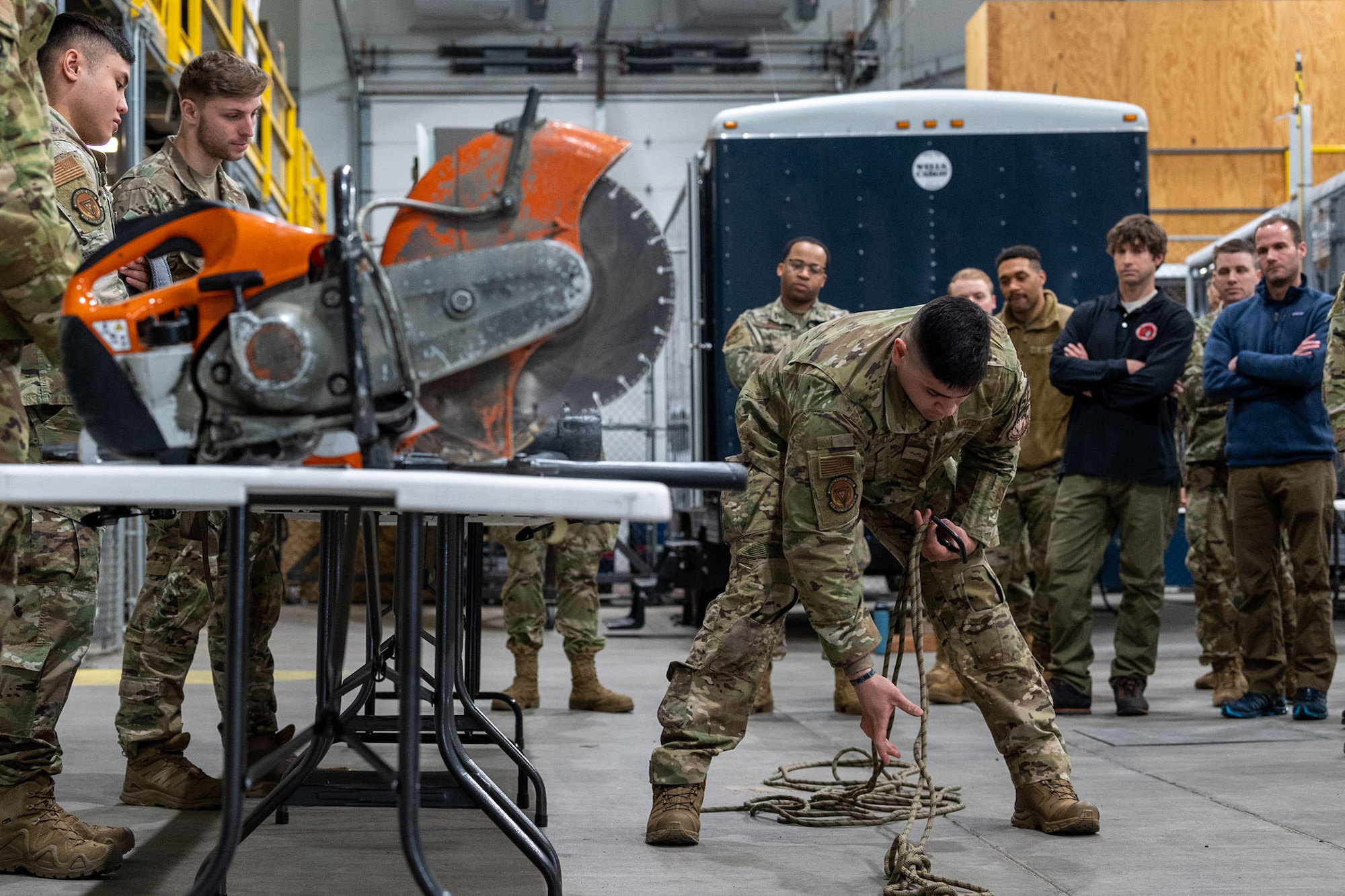 Senior Airman Alberto Rosendo-Diaz, 341st Security Operations Squadron tactical response force defender, gives a rope-tying demonstration to FBI agents and Malmstrom Airmen March 8, 2022, during a joint-training event at the emergency management warehouse on Malmstrom Air Force Base, Mont. Rope-tying involves rappelling from helicopters, which can provide access to difficult-to-reach locations when needed. Providing the FBI with advanced tools like rappelling improves the safety of the Montana community during emergency response efforts. (U.S. Air Force photo by Airman 1st Class Elijah Van Zandt)