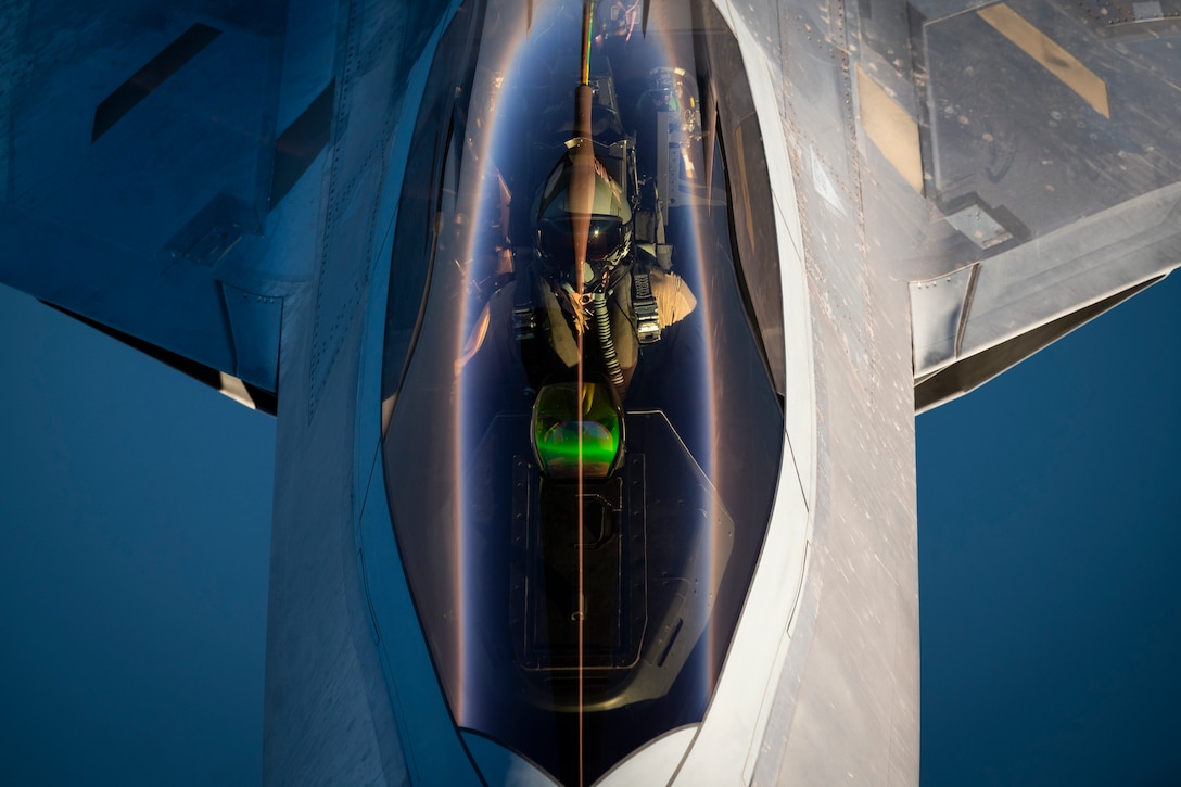 The cockpit of a military jet is seen from above.