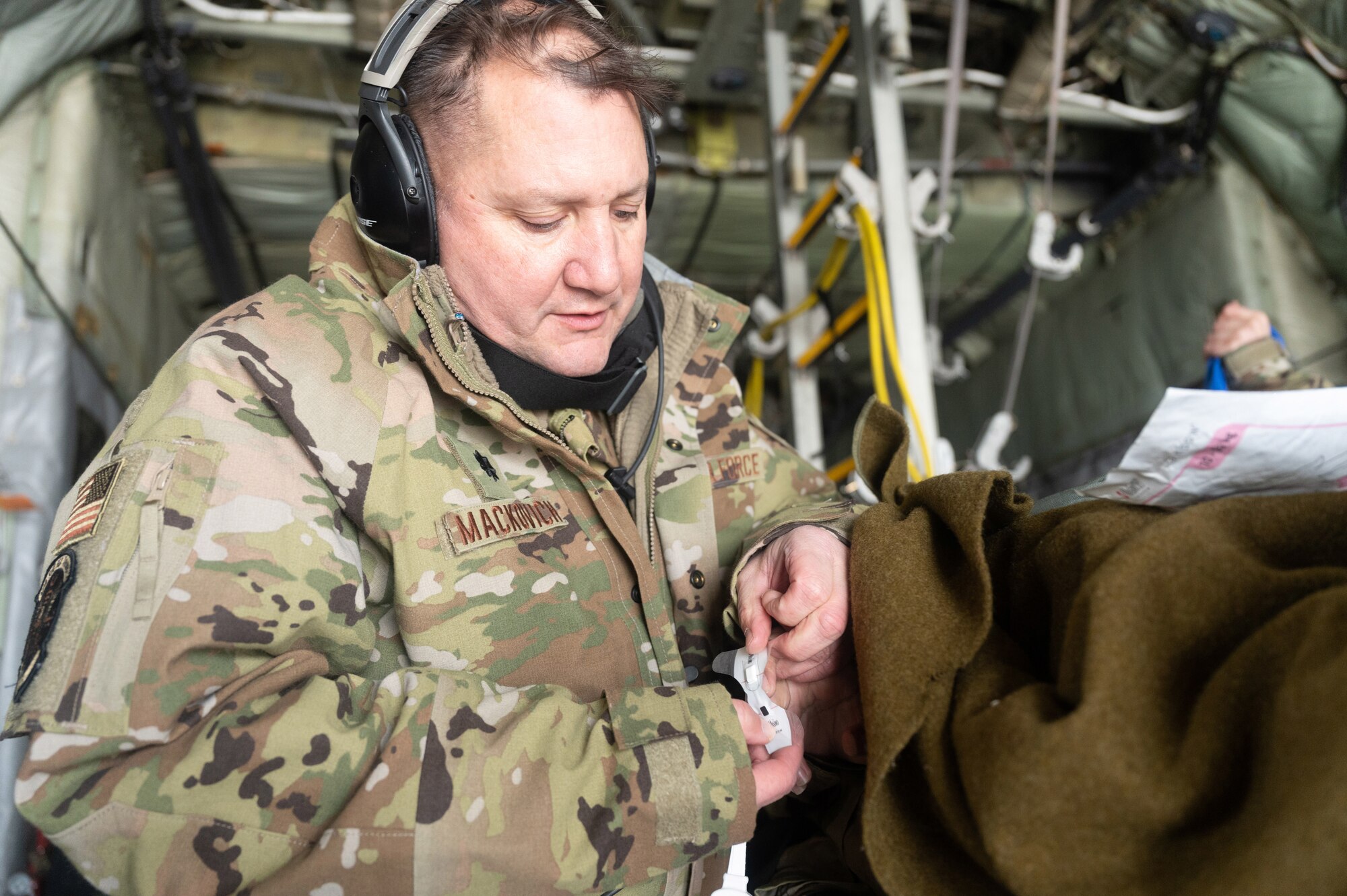 Lt. Col. Michael Mackovich, the 934th Critical Care Air Transportation Team commander, assists in treating a wounded service member in exercise Viking Shield, at Volk Field Air National Guard Base, Wis., April 7, 2022. Viking Shield is a 934th Airlift WIng led exercise designed to strengthen training in a degraded environment.(U.S. Air Force photo by Airman 1st Class Colten Tessness)