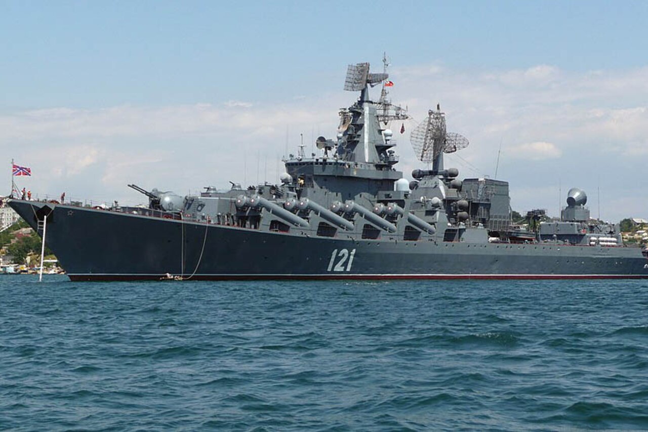 A ship displaying Russian flags is in water and near land.