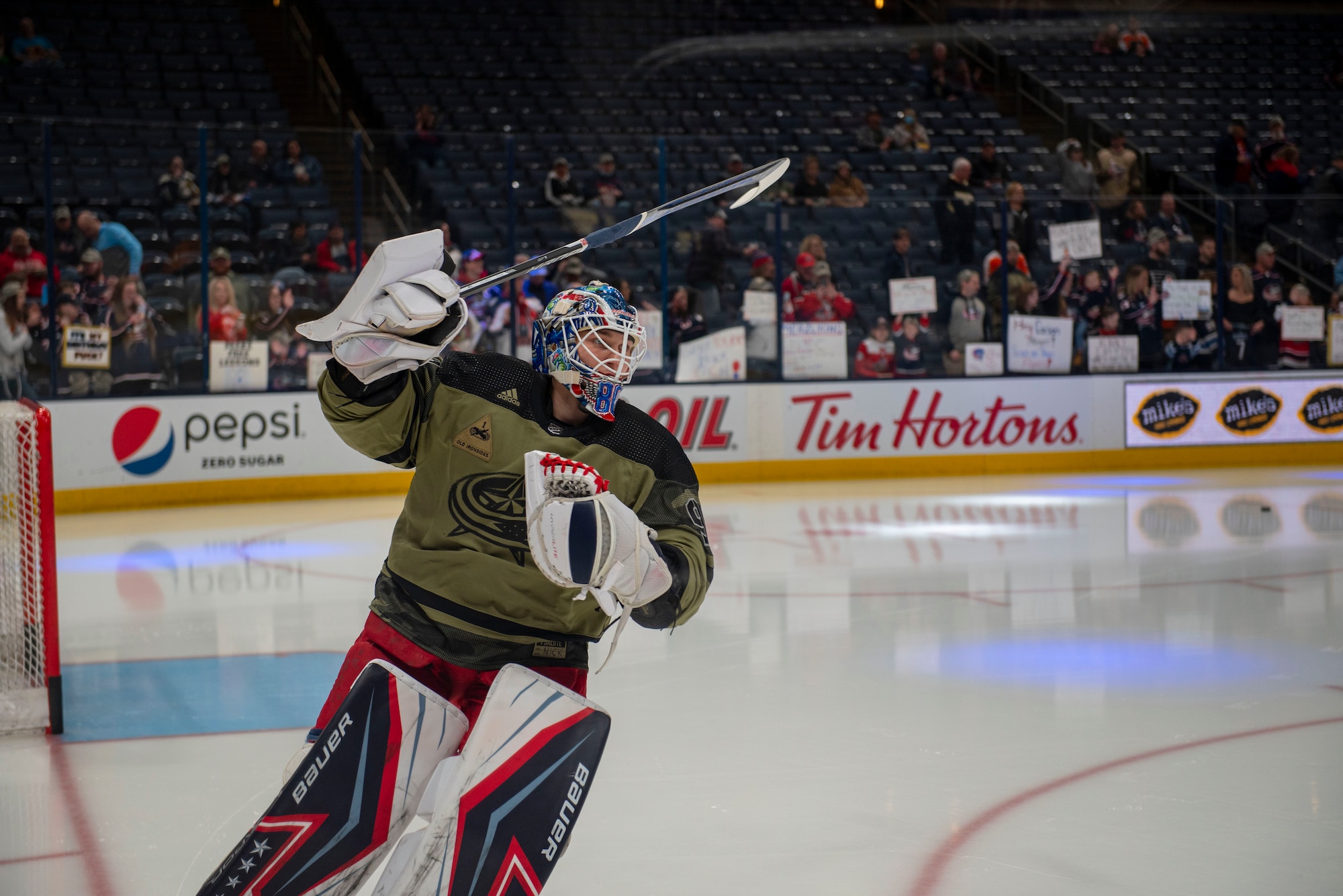 Columbus Blue Jackets goaltender Elvis Merzļikins warms up in a camouflage-style uniform as part of Military Appreciation Night on April 7, 2022, at Nationwide Arena, Columbus, Ohio. Prior to facing the Philadelphia Flyers, the team hosted a friendly alumni exhibition with the Wright Flyers, as well as several other recognition activities throughout the night. (U.S. Air Force photo by Senior Airman Jack Gardner)