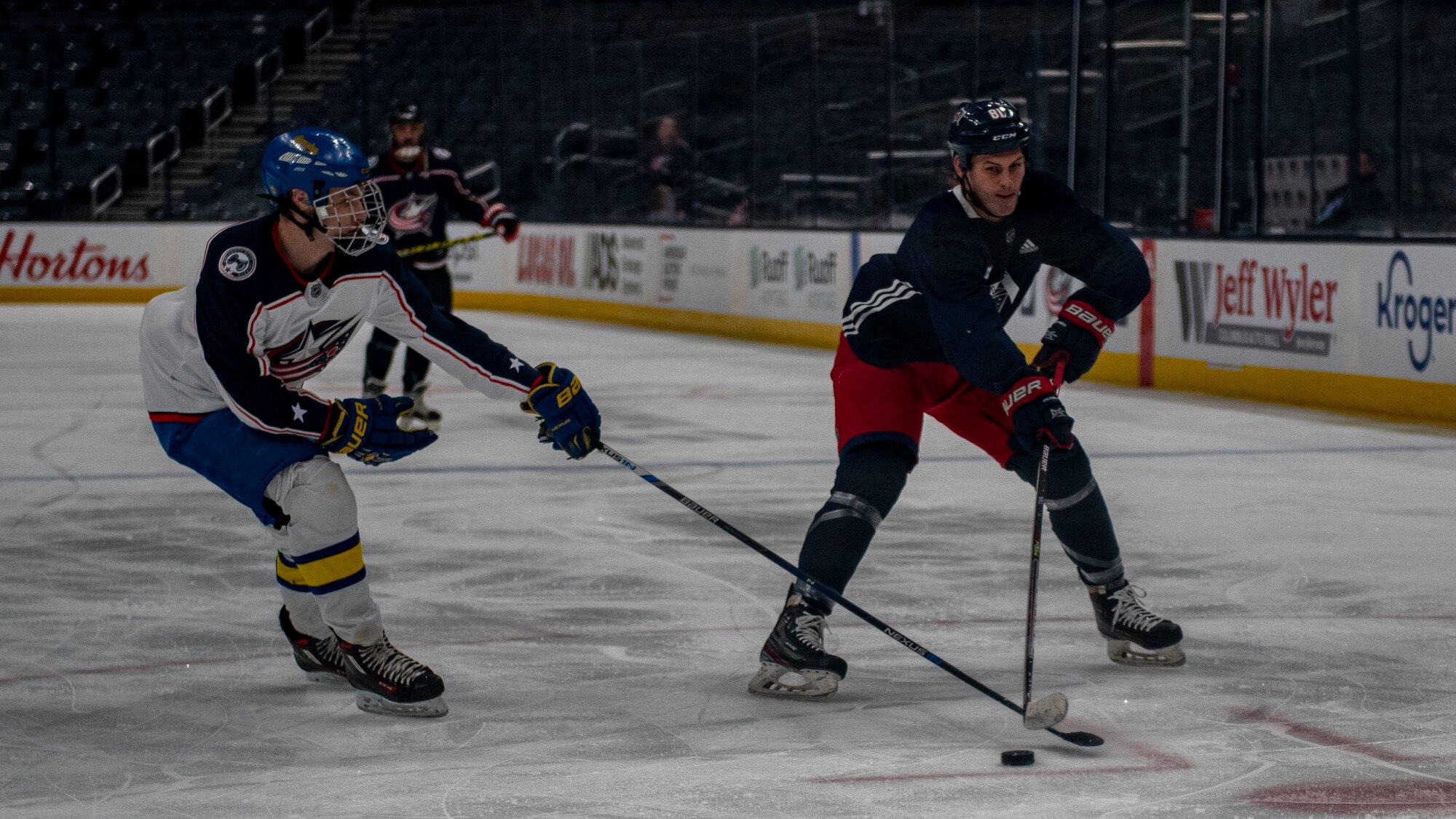 Sam Medvec (left) plays defense against former Columbus Blue Jackets winger Chris Clark during the Military Appreciation Night alumni game April 7, 2022, at Nationwide Arena, Columbus, Ohio. The friendly exhibition featured former Blue Jackets players and the Wright Flyers, a recreation team made up of military and civilian personnel from Wright-Patterson Air Force Base, prior to Columbus’s game against the Philadelphia Flyers. (U.S. Air Force photo by Senior Airman Jack Gardner)