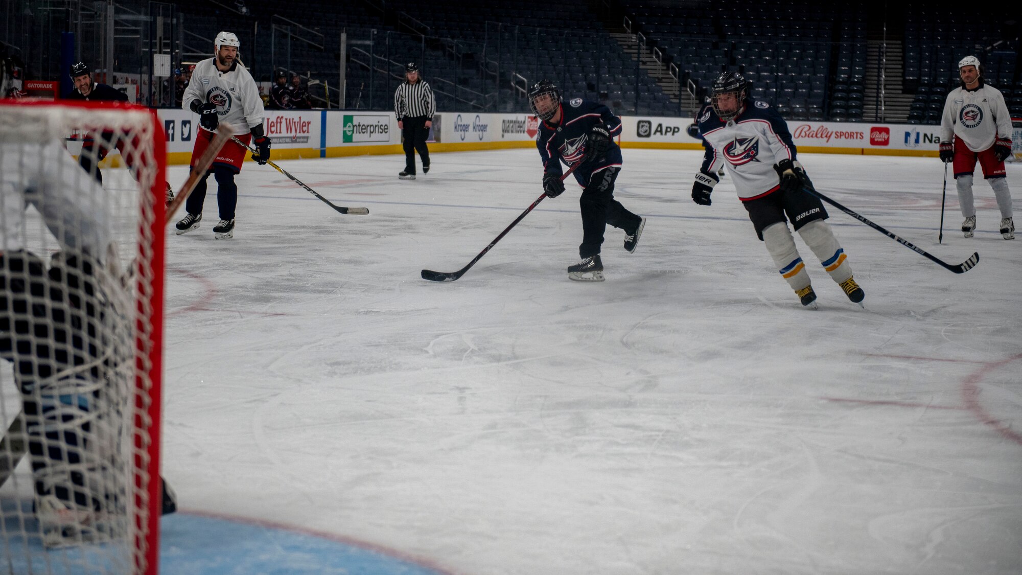 Taylor Foy (blue jersey) skates down center ice and takes a shot on goal during the Military Appreciation Night alumni game April 7, 2022, at Nationwide Arena, Columbus, Ohio. The friendly exhibition featured former Columbus Blue Jackets players and the Wright Flyers, a recreation team made up of military and civilian personnel from Wright-Patterson Air Force Base. (U.S. Air Force photo by Senior Airman Jack Gardner)