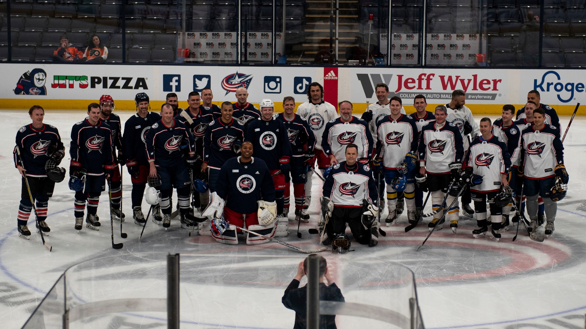 Players who competed in the alumni scrimmage take a group photo April 7, 2022, at Nationwide Arena, Columbus, Ohio. Prior to facing the Philadelphia Flyers, the Columbus Blue Jackets kicked off their annual Military Appreciation Night with a friendly exhibition game featuring former players and the Wright Flyers, a recreation team made up of military and civilian personnel from Wright-Patterson Air Force Base. (U.S. Air Force photo by Senior Airman Jack Gardner)