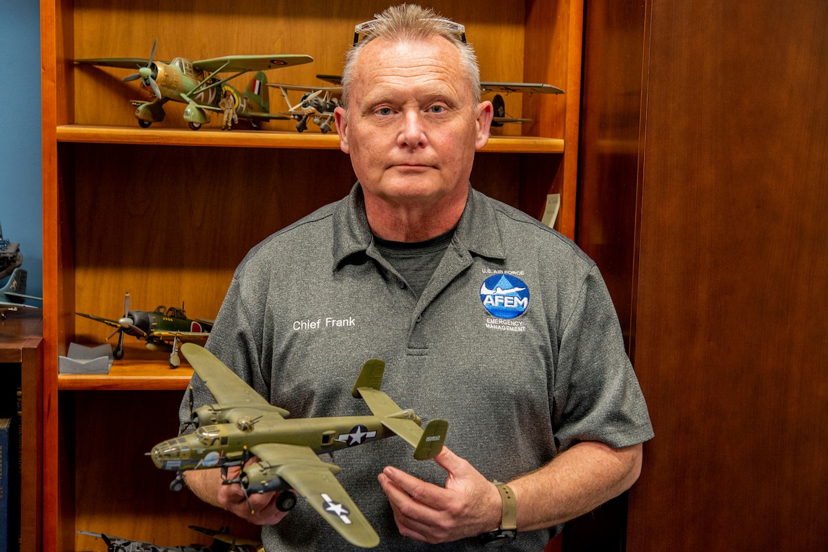 David Frank, the 788th Civil Engineer Squadron’s Emergency Management chief, holds a model version of the B-25 on April 6, 2022, at Wright-Patterson Air Force Base. He built a collection of models for the 80th anniversary of the Doolittle Raid, in which 16 B-25s took off from the USS Hornet and performed bombing strikes on Tokyo during World War II. (U.S. Air Force photo by Senior Airman Jack Gardner)