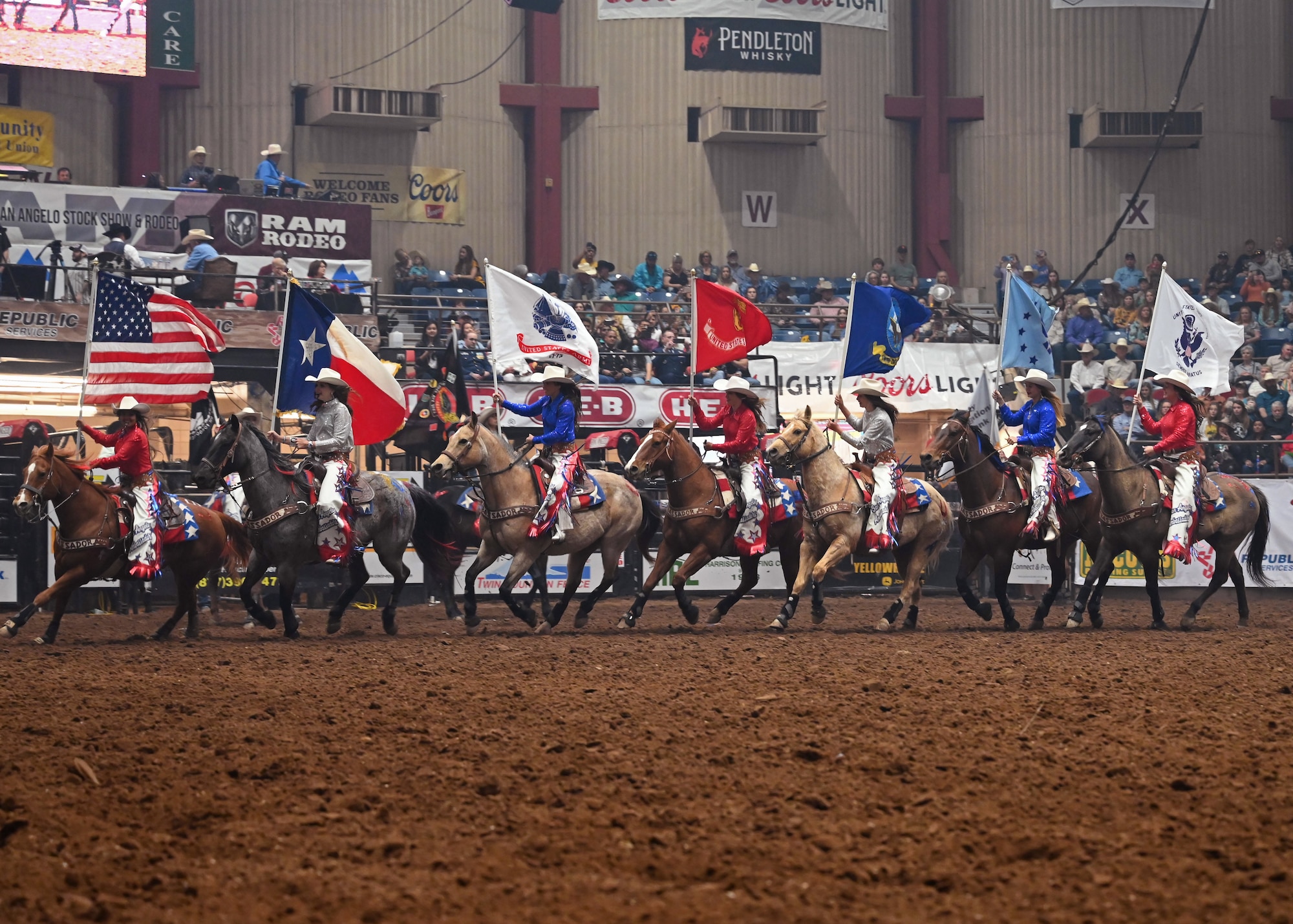 Rodeo participants ride around the ring carrying flags during Military Appreciation Night at the San Angelo Stock Show and Rodeo, April 13, 2022. The flying of the flags is a part of a long-standing tradition tied to the annual event. (U.S. Air Force photo by Airman 1st Class Sarah Williams)