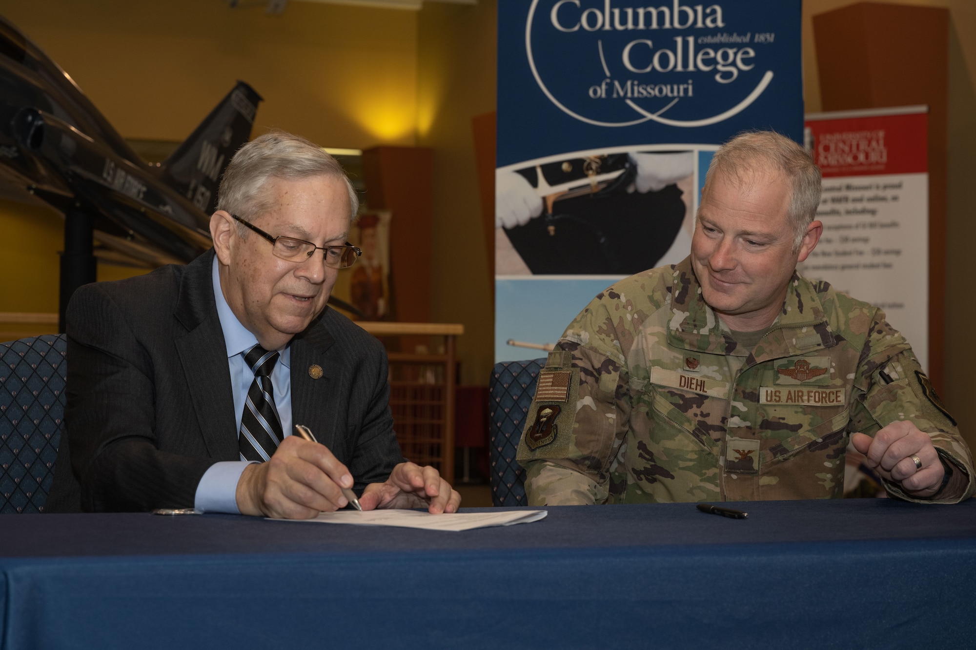 U.S. Air Force Col. Daniel Diehl, Commander of the 509 Bomb Wing, signs a memorandum of understanding between Columbia College and the 509th Bomb Wing on Whiteman Air Force Base on April 14,2022. The memorandum acknowledges Columbia College's partnership by opening it's programs to the Air Force Voluntary Education Program (U.S. Air Force Photo by Airman 1st Class Bryson Britt)
