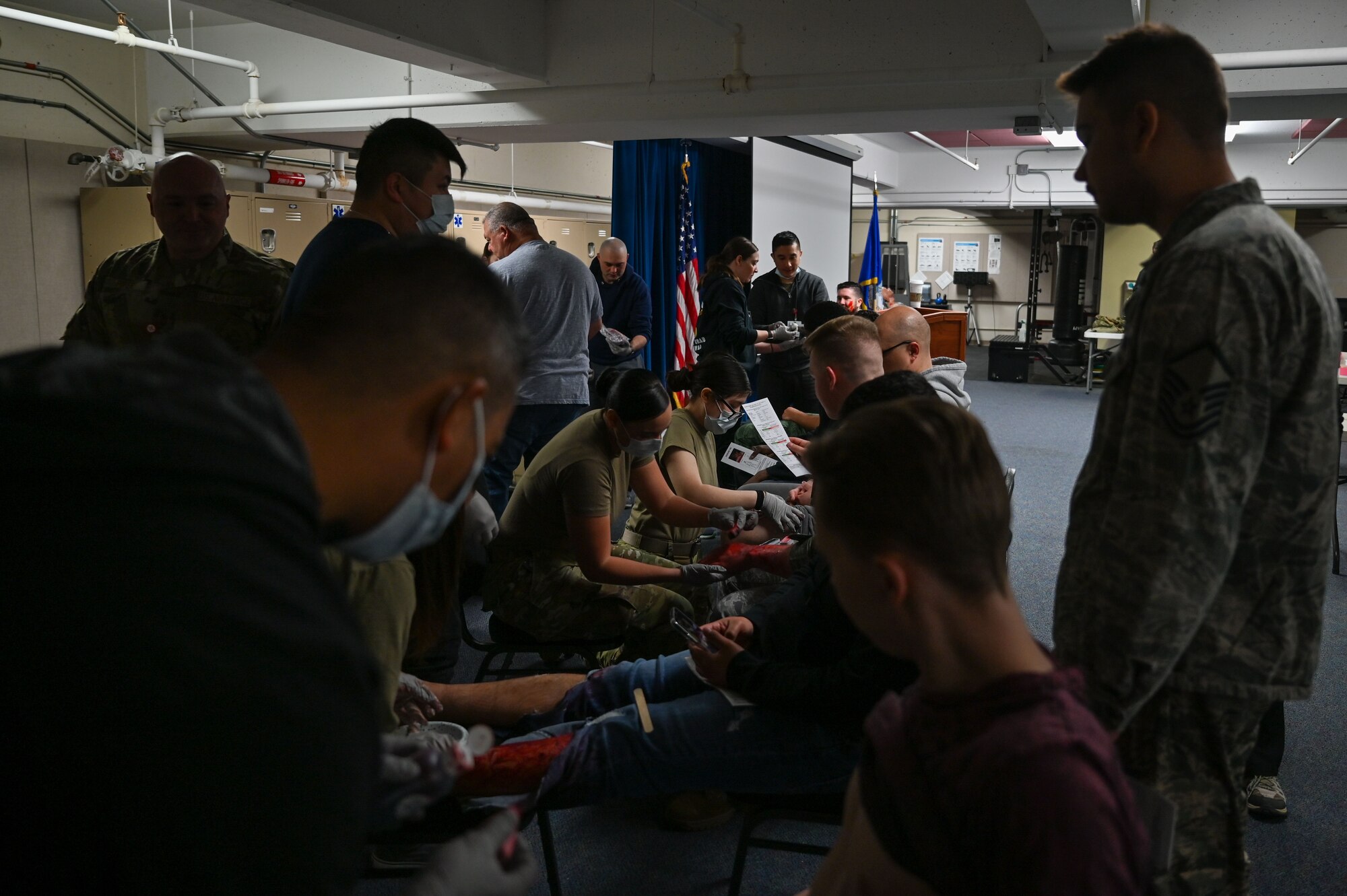 Members from the 22nd Medical Group apply makeup, fake wounds, and blood to volunteers from various squadrons around McConnell Air Force Base, Kansas, April 8, 2022.