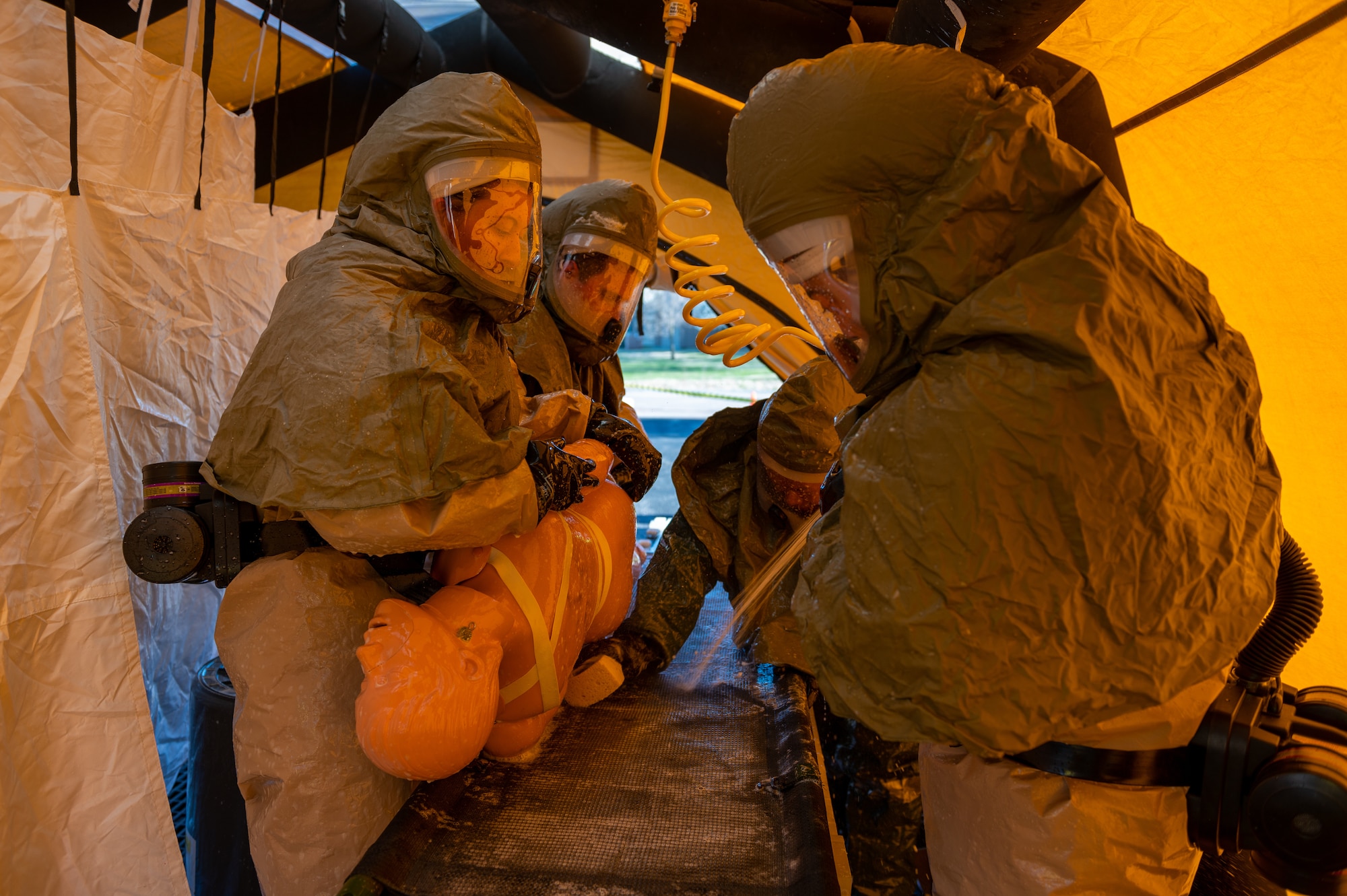 Members from the 22nd Medical Group, wash off a simulated casualty to find any wounds during exercise Ready Eagle April 8, 2022, at McConnell Air Force Base, Kansas.
