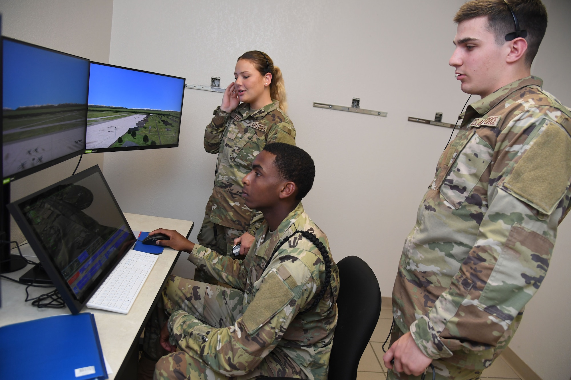 U.S. Air Force Airmen Isabella Fitzegerald, Jayden Ali and Luke Pietrykowski, 334th Training Squadron students, use a condensed air traffic control tower simulator for training inside Erwin Manor at Keesler Air Force Base, Mississippi, April 13, 2022. Four trainers were installed to allow students the opportunity to increase tower control contact hours and to provide students additional study and familiarization time outside the classroom. (U.S. Air Force photo by Kemberly Groue)