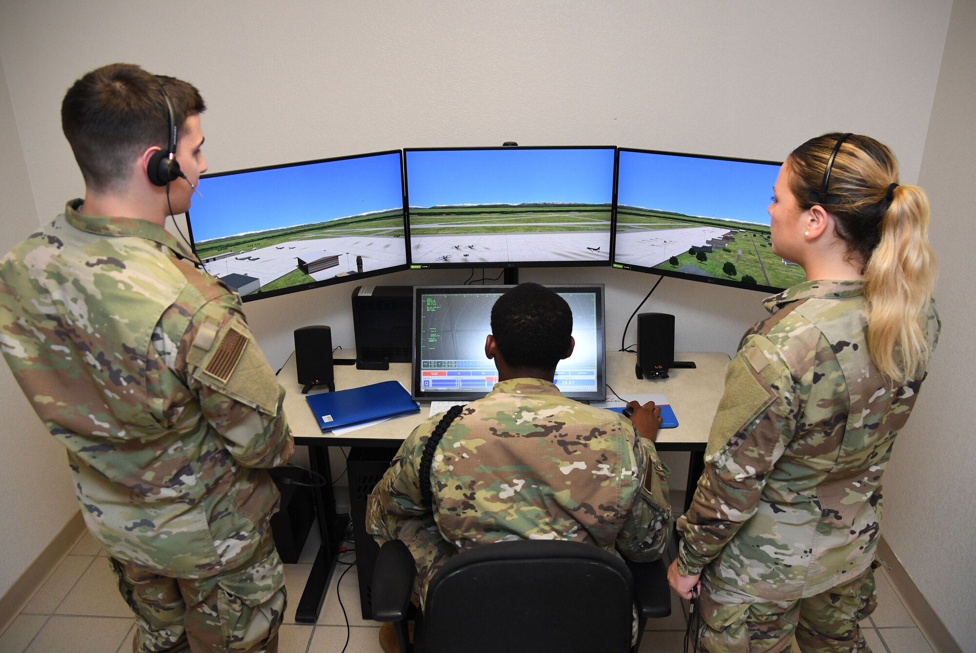 U.S. Air Force Airmen Luke Pietrykowski, Jayden Ali and Isabella Fitzegerald, 334th Training Squadron students, use a condensed air traffic control tower simulator for training inside Erwin Manor at Keesler Air Force Base, Mississippi, April 13, 2022. Four trainers were installed to allow students the opportunity to increase tower control contact hours and to provide students additional study and familiarization time outside the classroom. (U.S. Air Force photo by Kemberly Groue)
