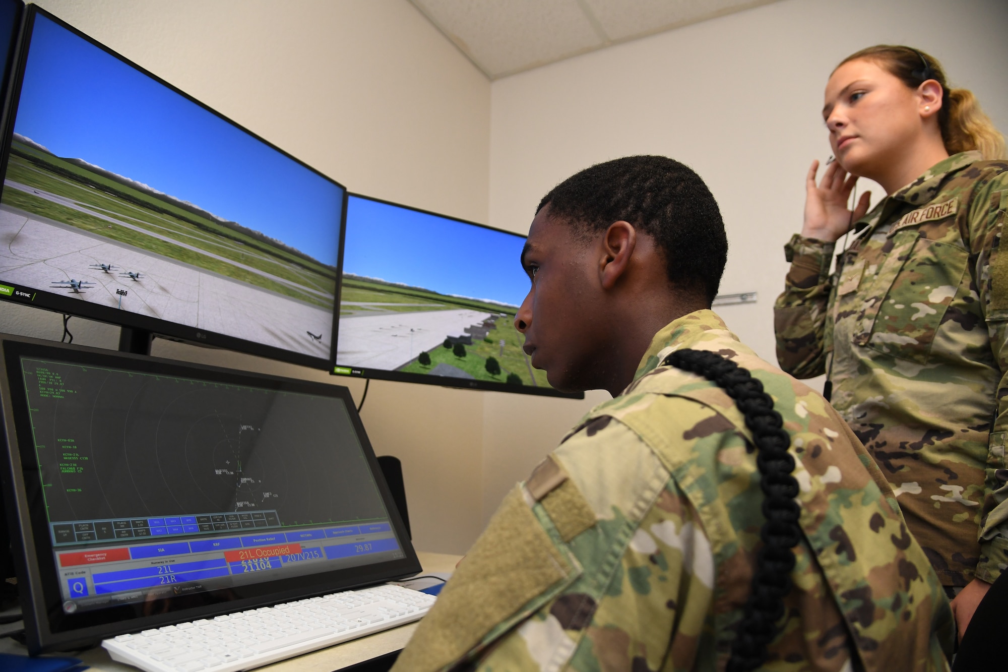 U.S. Air Force Airmen Jayden Ali and Isabella Fitzegerald, 334th Training Squadron students, use a condensed air traffic control tower simulator for training inside Erwin Manor at Keesler Air Force Base, Mississippi, April 13, 2022. Four trainers were installed to allow students the opportunity to increase tower control contact hours and to provide students additional study and familiarization time outside the classroom. (U.S. Air Force photo by Kemberly Groue)