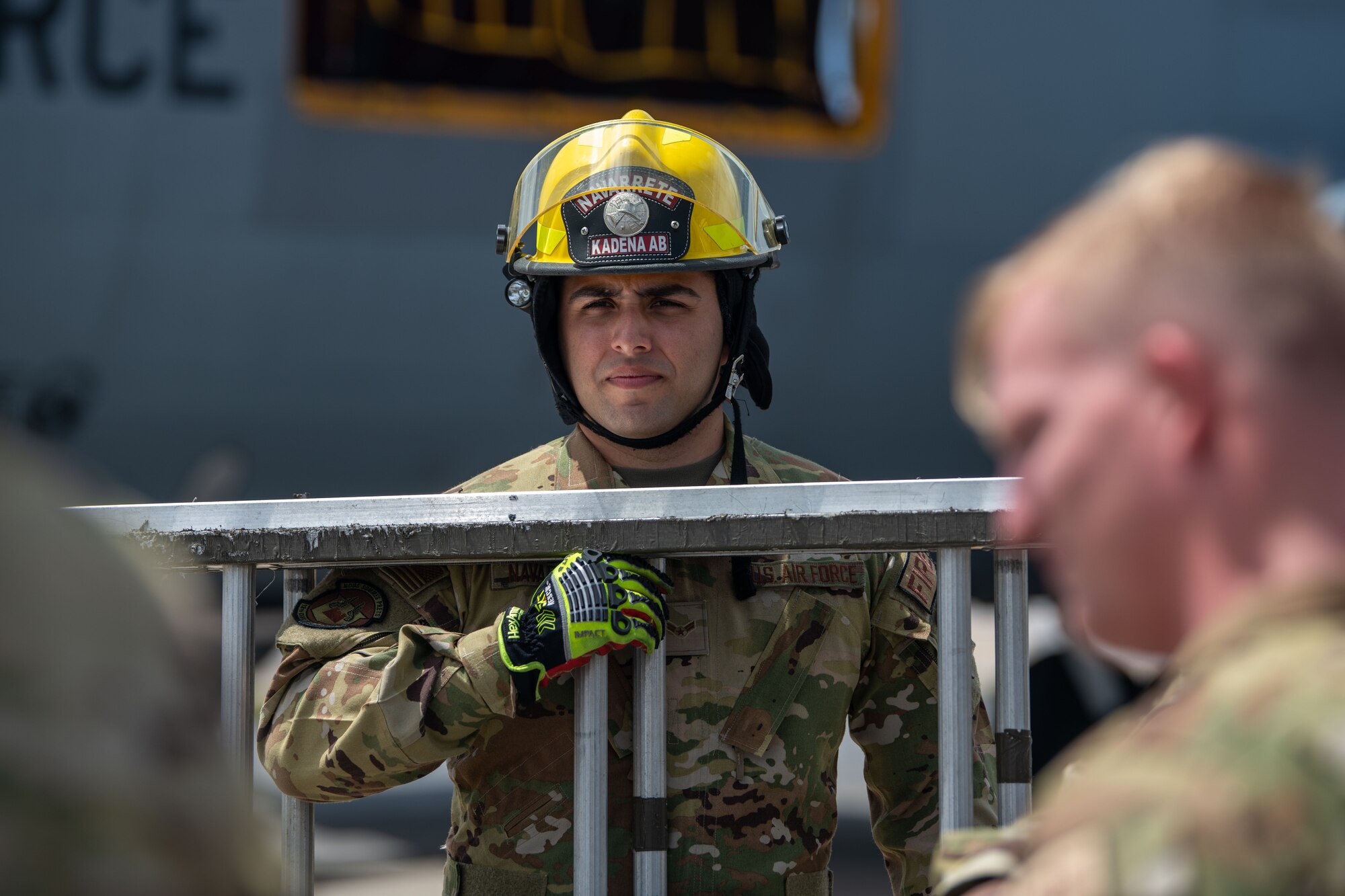 Airman holds a ladder.