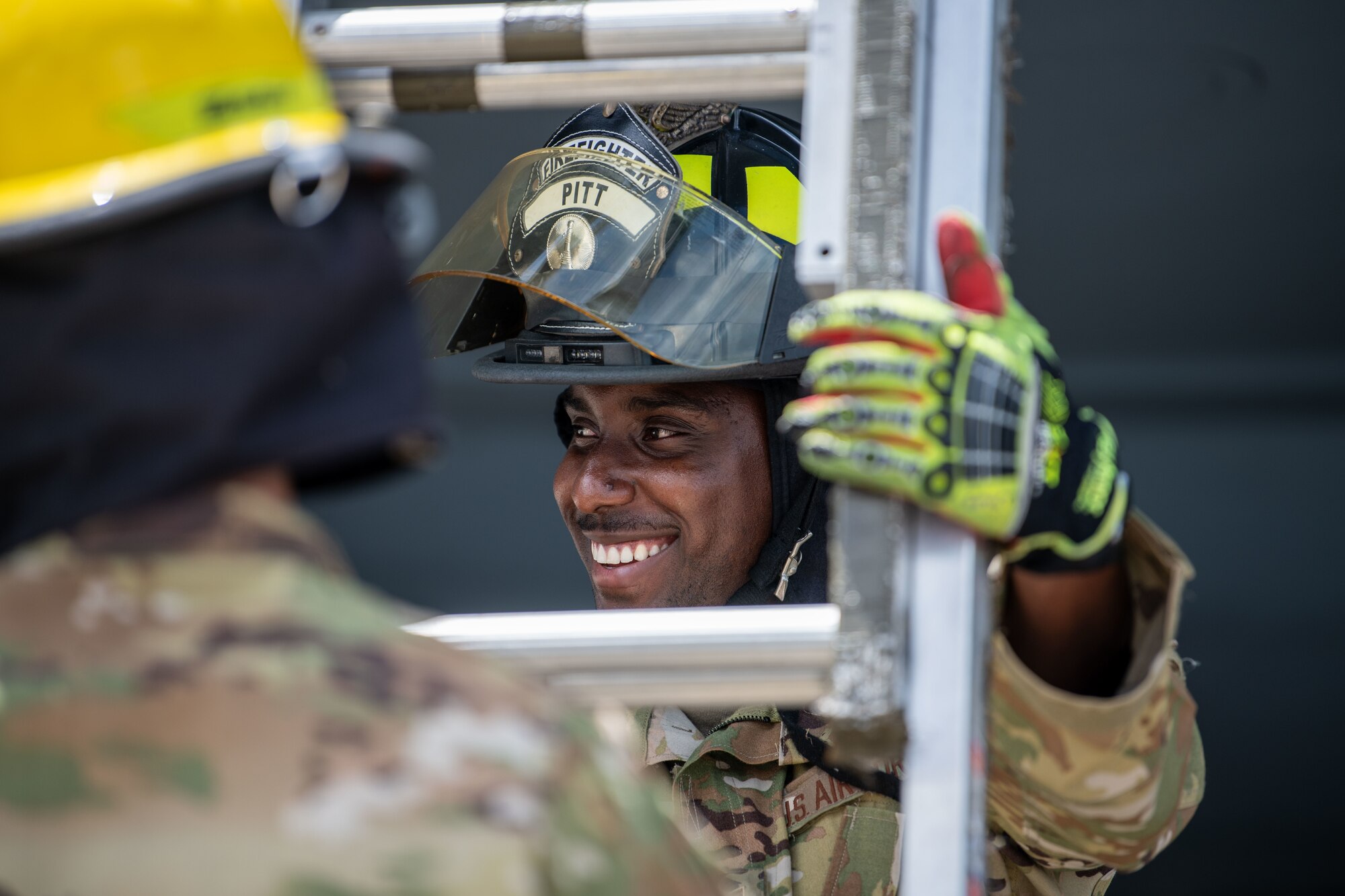 Airman holds a ladder.