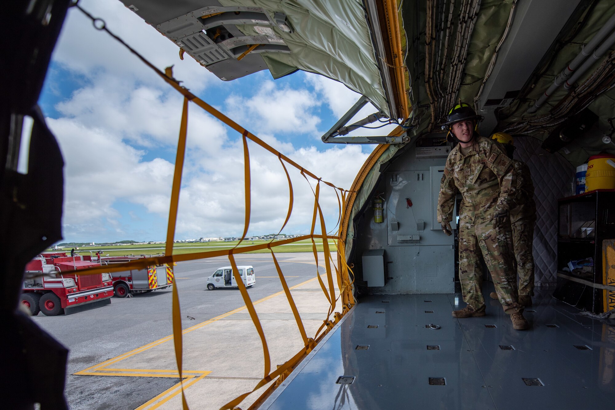 Airmen open an airplane cargo door.