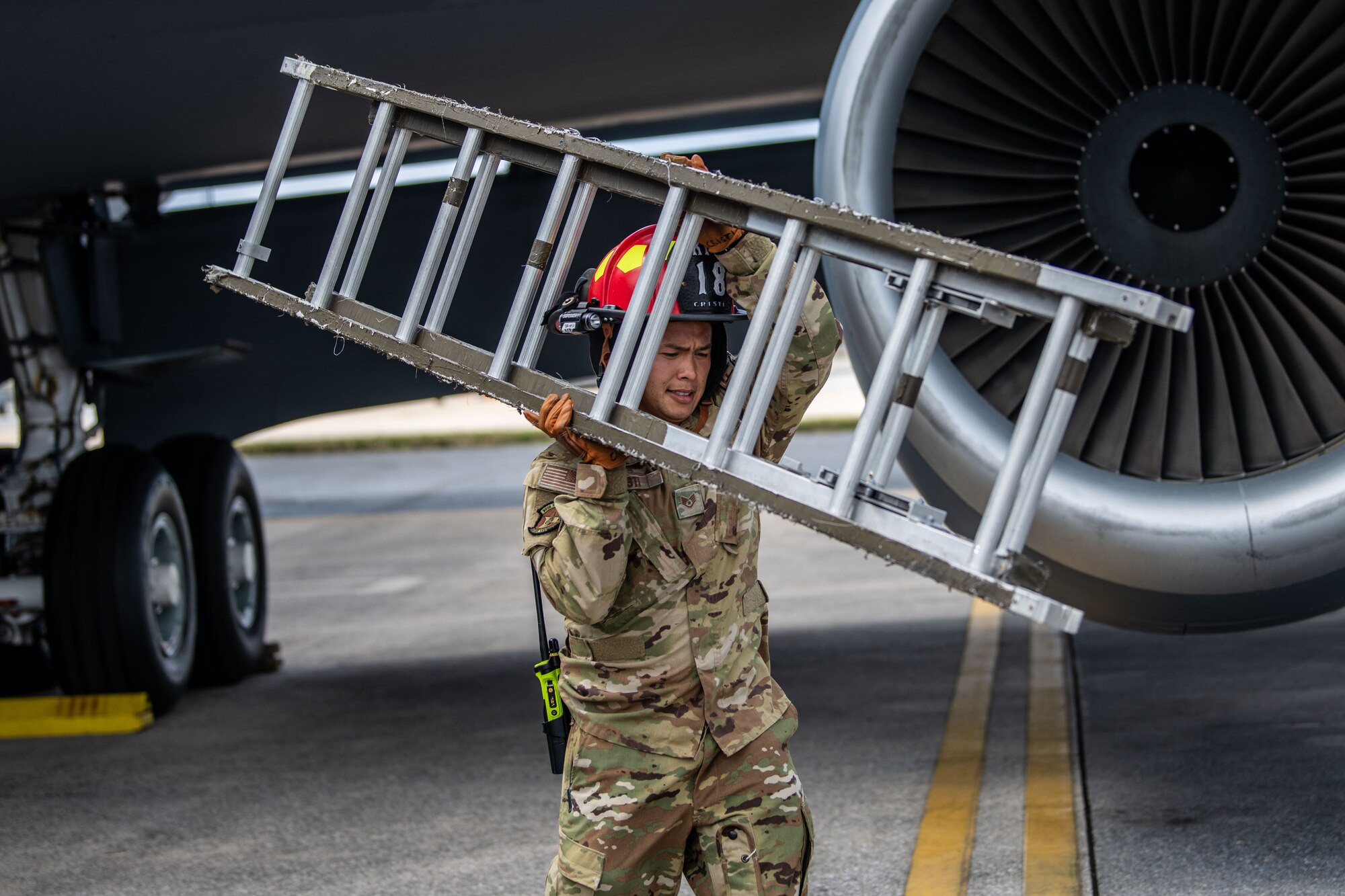 Airman carries a ladder.