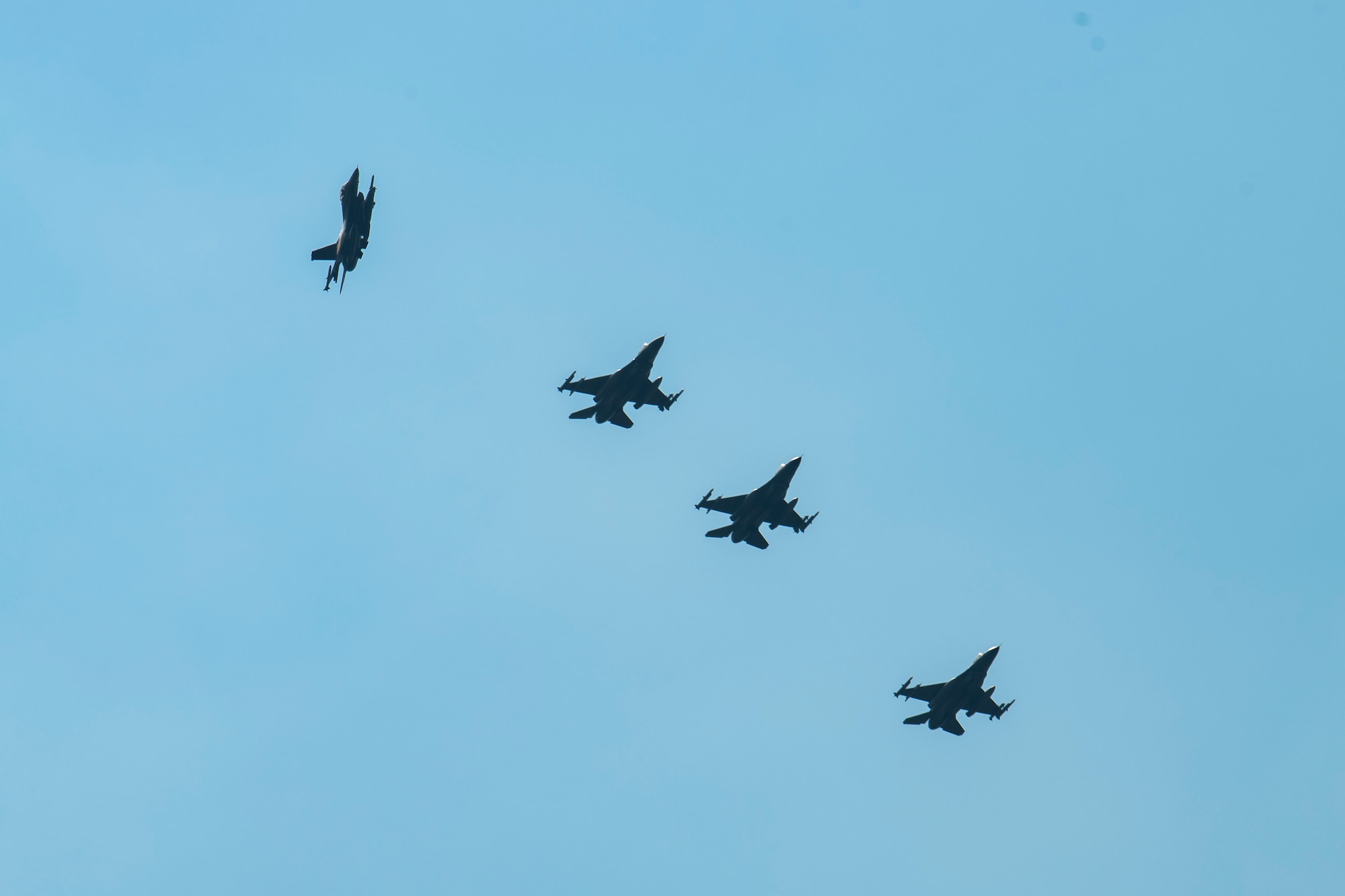 Four F-16s fly in formation.