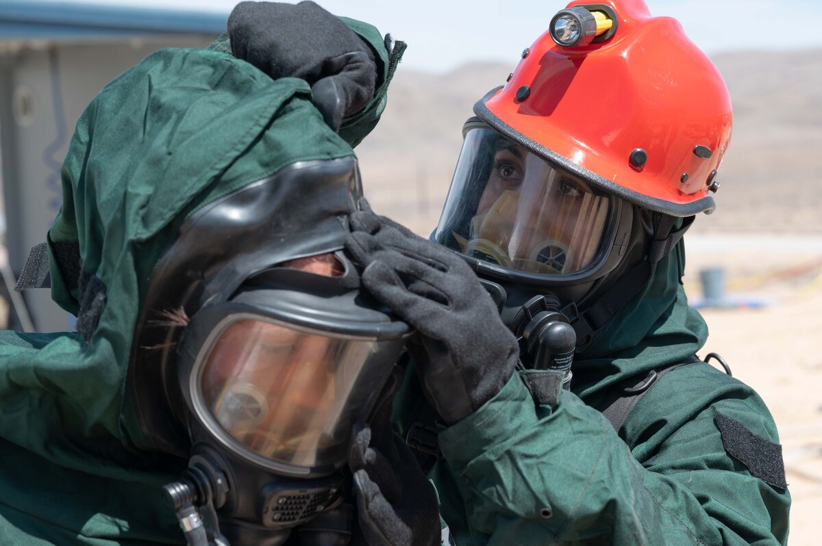 Master Sgt. Rachael Kargol assists Tech. Sgt. Christine Wulwer with removing her chemical warfare ensemble during an in-person combined training event with other Air and Army National Guard units this week in Las Vegas. Both are FSS Specialists who have volunteered for the 162nd FSS FSRT mission.