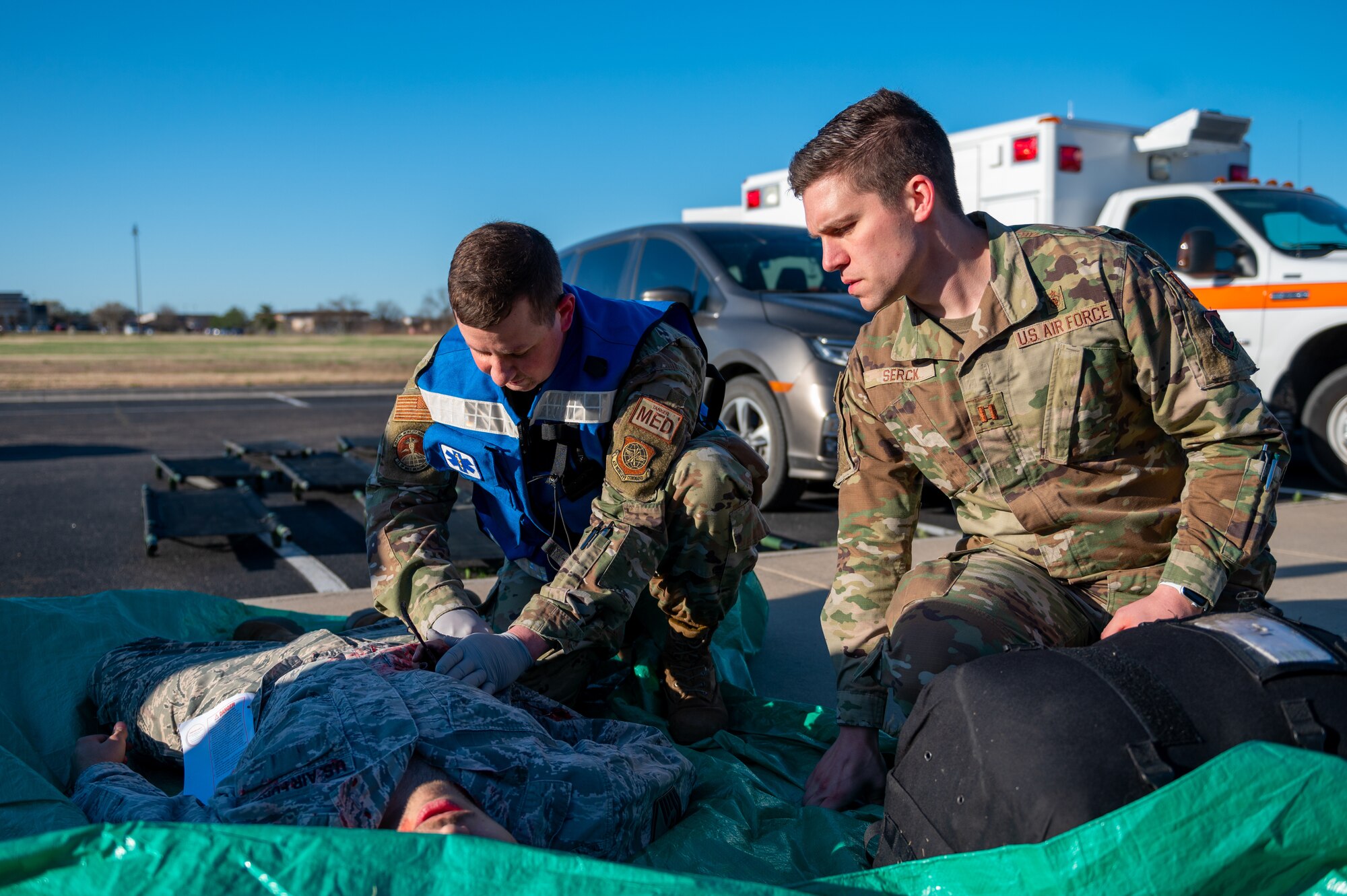 Senior Airman Sean Skinner, 22nd Operational Medical Readiness Squadron flight operational medical technician, and Capt. Jordan Serck 22nd OMRS, element chief of base operational medicine clinic, perform Tactical Combat Casualty Care on a simulated injury during Exercise Ready Eagle April 8, 2022, at McConnell Air Force Base, Kansas