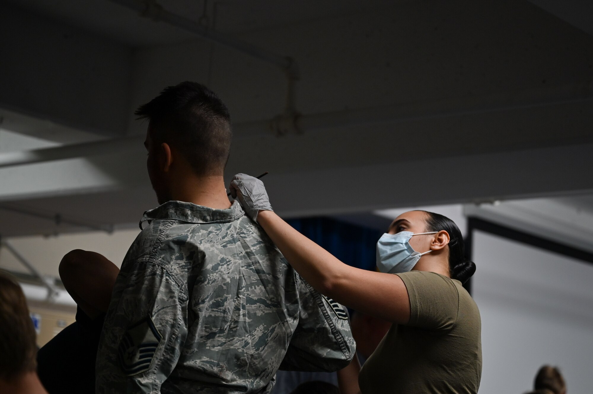 Airman 1st Class Caitlin Hawery, 22nd Medical Group mental health technician, paints fake blood onto Airman Christopher Crawford, 22nd Aircraft Maintenance Squadron crew chief, April 8, 2022, at McConnell Air Force Base, Kansas.