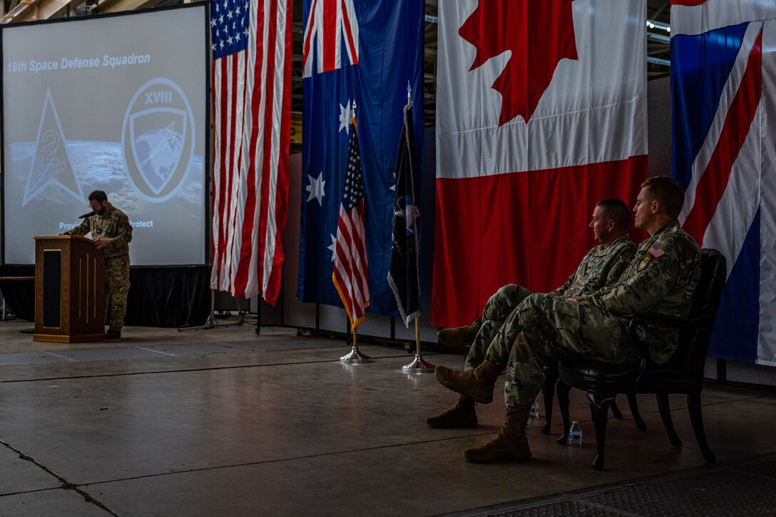 U.S. Space Force Lt. Col. Matthew Lintker, 18th Space Defense Squadron commander, right, and U.S. Space Force Col. Marc Brock, Space Delta 2 commander, middle, sit as the official party for the 18 SDS during a re-designation ceremony at Vandenberg Space Force Base, Calif., April 13, 2022. Brock was the presiding officer for the ceremony.  The 18 SDS will continue to be U.S. Space Command’s entry point and storefront for international cooperation and partnerships, while listening and responding to the needs of partners to improve sharing products, services and practices. (U.S. Space Force photo by Tech. Sgt. Luke Kitterman)