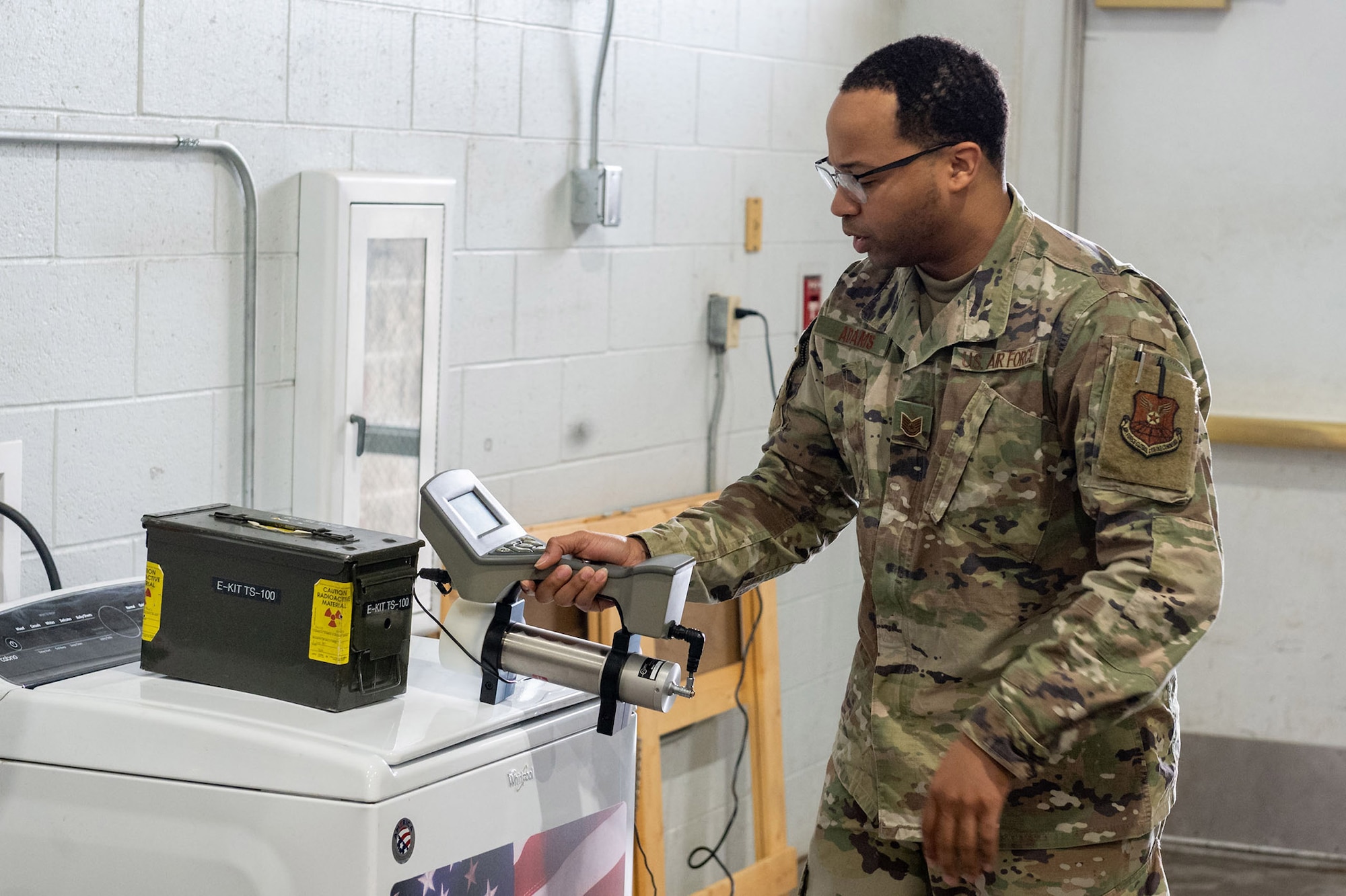 Tech. Sgt. Darryl Adams, 341st Bioenvironmental Engineering Squadron NCO in-charge, scans an ammo can for radiation during a joint-training event March 8, 2022, at the emergency management warehouse on Malmstrom Air Force Base, Mont. Adams is using a SAM-940 radiation device, which quantifies and identifies radioactive isotopes. Outside agencies, such as the FBI, rely on bioenvironmental personnel to detect dangerous chemicals on and around the installation during emergency situations. (U.S. Air Force photo by Airman 1st Class Elijah Van Zandt)