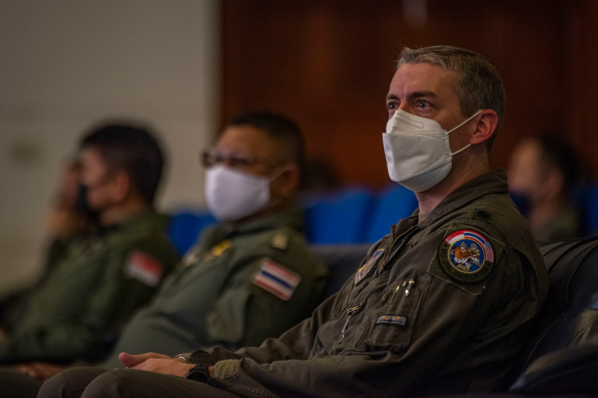 U.S., Singapore and Thailand leaders sit in the audience of a brief for Exercise Cope Tiger.