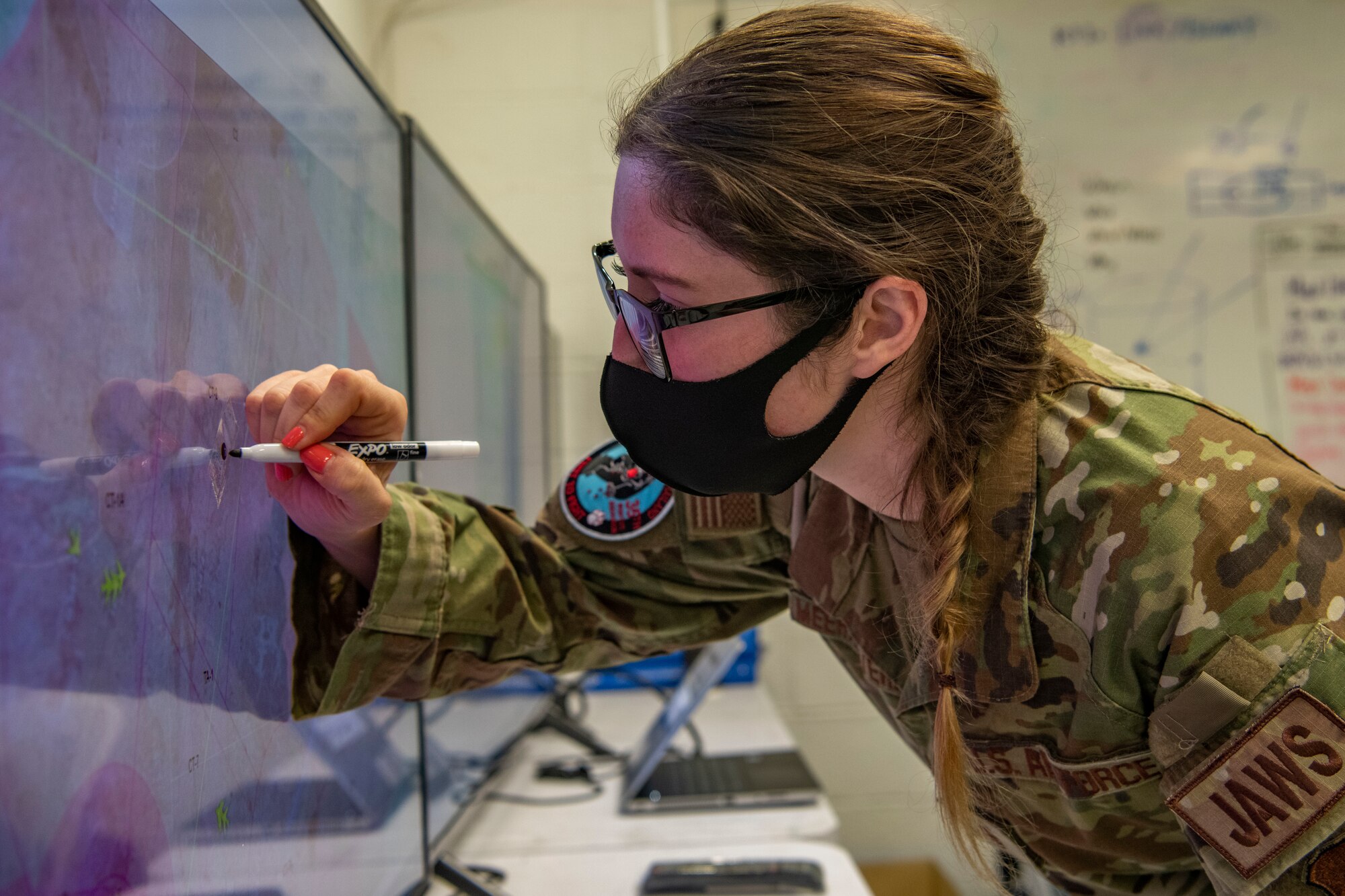 An intelligence officer writes on a screen.