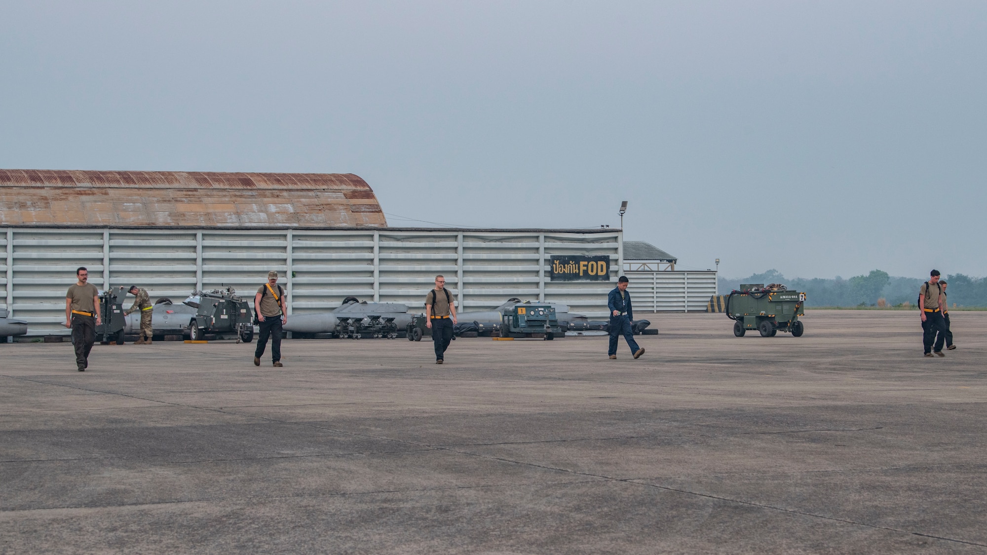 Airmen conduct a walk to remove foreign objects from the flightline.