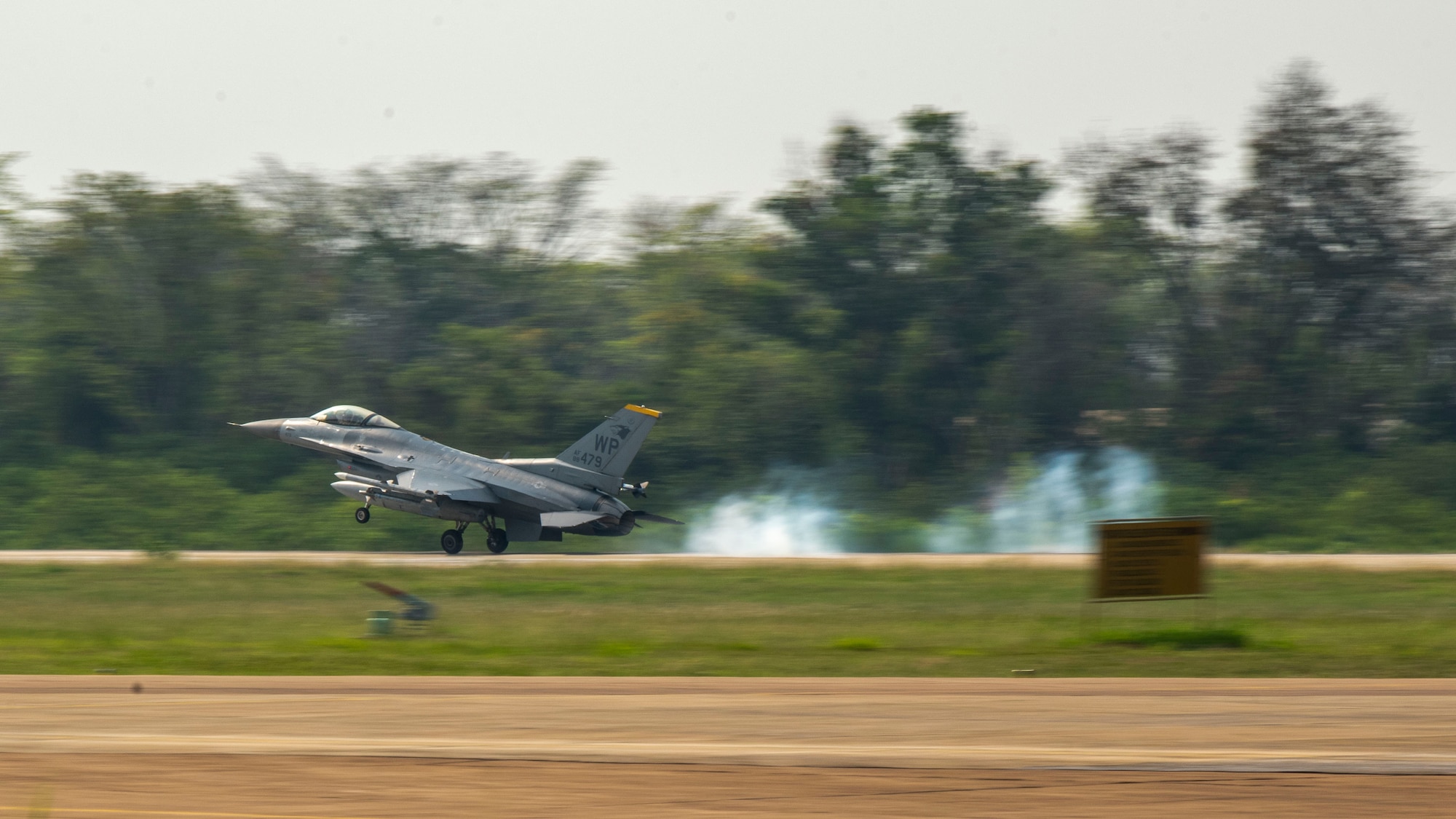 An F-16 lands on the flight line.