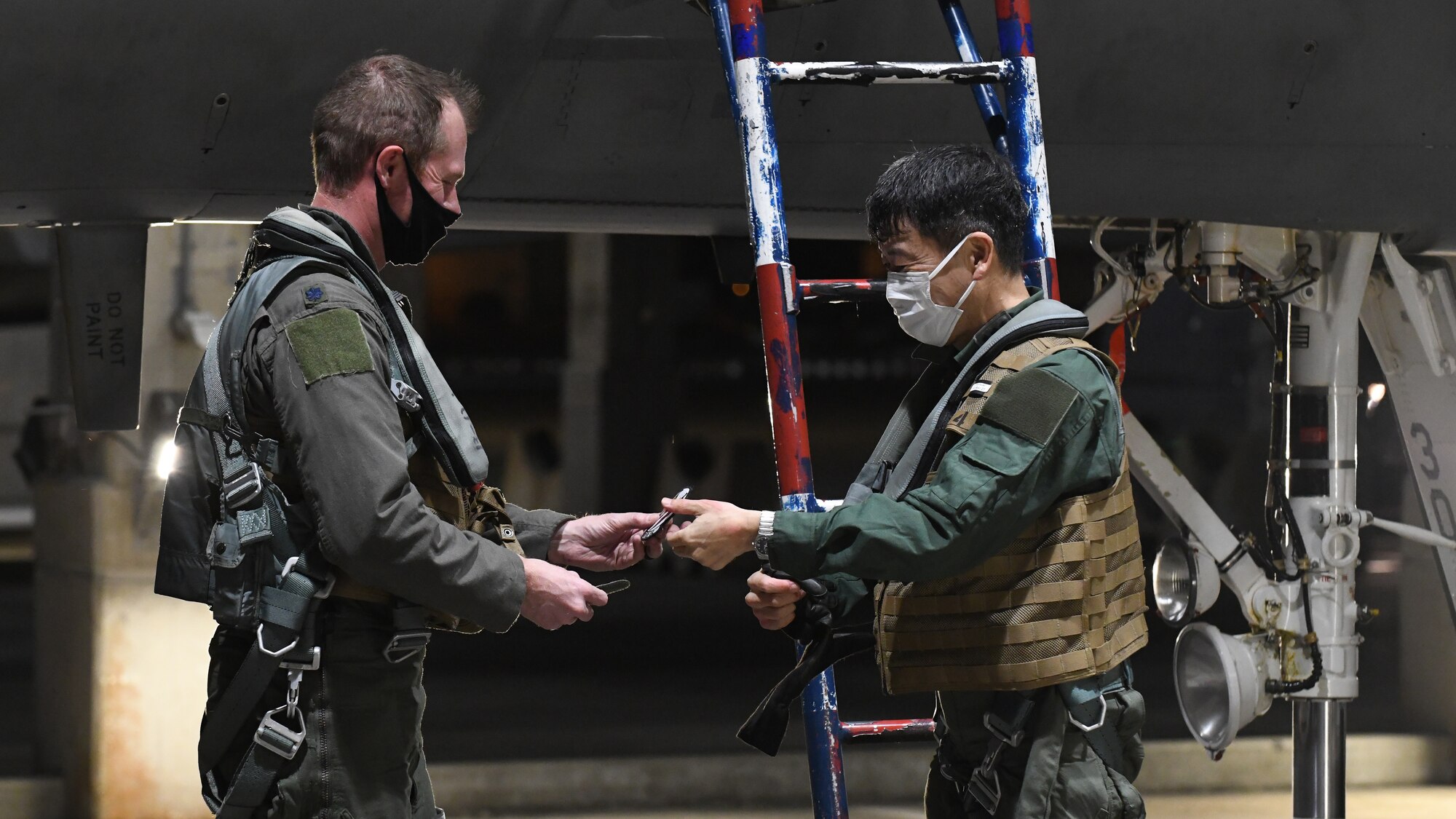 Japan Air Self-Defense Force Lt. Gen. Masahito Yajima, Southwestern Air Defense Force commander, trades patches with a 44th Fighter Squadron pilot after a familiarization flight at Kadena Air Base, Japan, April 12, 2022. Team Kadena Airmen routinely participate in training events and exercises with JASDF counterparts to strengthen interoperability, ensure the defense of Japan and maintain a free and open Indo-Pacific. (U.S. Air Force photo by Staff Sgt. Benjamin Raughton)