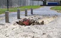 Spc. Brandon Mitchell, 337th Engineer Battalion, 55th Maneuver Enhancement Brigade, one of 15 Pennsylvania Army National Guard Soldiers competing in the 2022 state Best Warrior Competition, does the low crawl in the obstacle course April 11, 2022, at Fort Indiantown Gap, Pa. The Soldiers competed in nine events designed to test their physical and mental endurance: night land navigation, a medical event, Army Combat Fitness Test, a written exam, a mystery event, the obstacle course, a 12-mile ruck march, and finally, a leadership/appearance board.