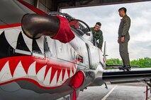 U.S. Air Force Maj. Dan Jackson, left, 6th Special Operations Squadron combat aviation advisor evaluator pilot, appraises a Philippine Air Force A-29 Super Tucano from the cockpit alongside his former classmate, Philippine Air Force Maj. Dennis Marzo, right, 15th Strike Wing A-29 pilot, during exercise Balikatan at Clark Air Base, Pampanga, Philippines, April 5, 2022.