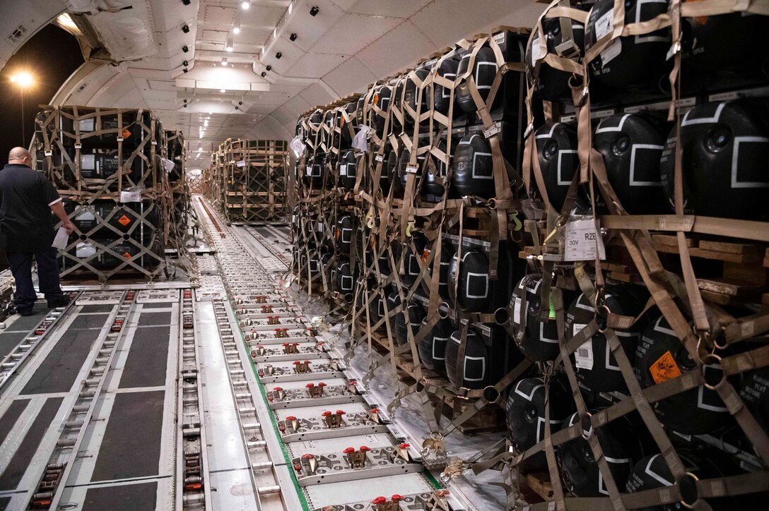 Rows of pallets of cargo sit inside an aircraft.