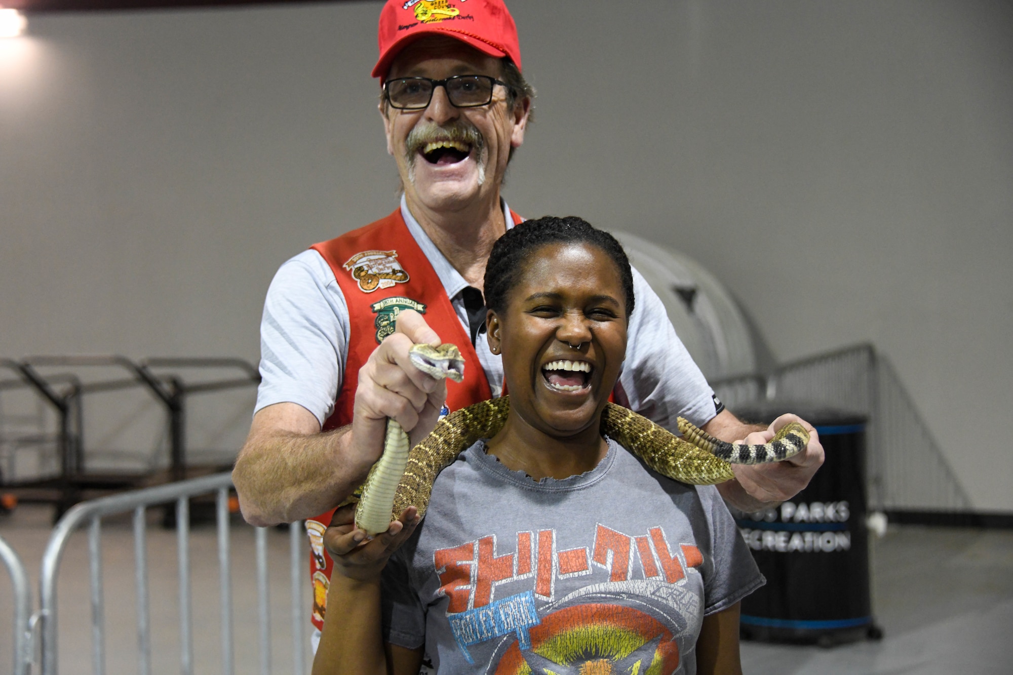 U.S. Air Force Airman 1st Class Miyah Gray, 97th Air Mobility Wing public affairs apprentice, poses with a rattlesnake at the Committee of 100 dinner event in Altus, Oklahoma, April 11, 2022. The rattlesnakes were shown to Airmen and their families to familiarize them with natural dangers living in the area. (U.S. Air Force photo by Senior Airman Kayla Christenson)