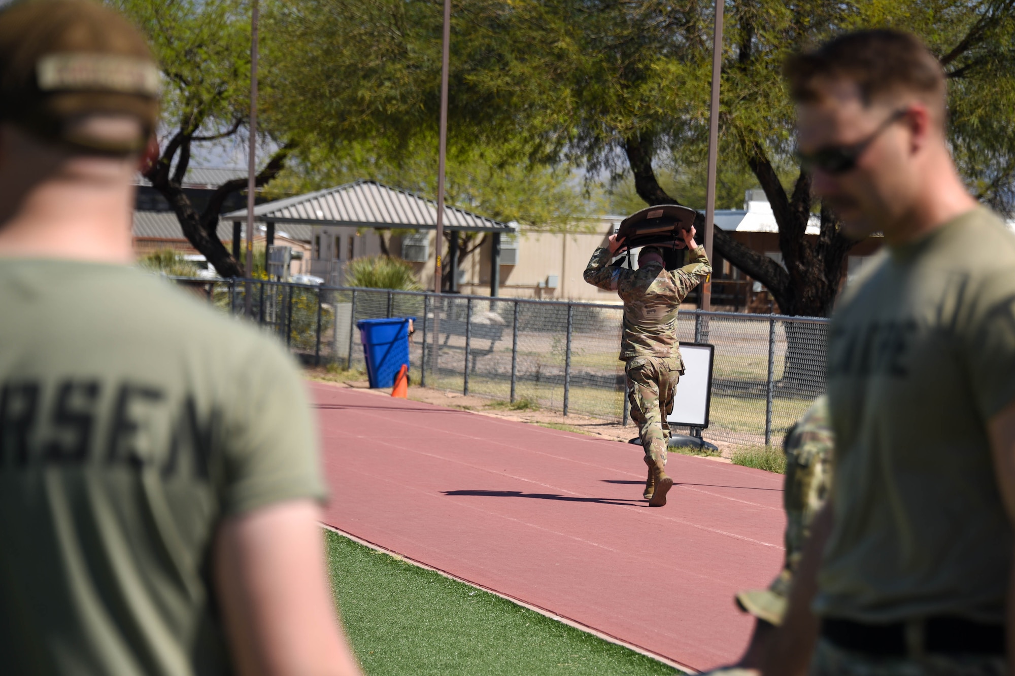 A photo of an Airman running with a riot shield.