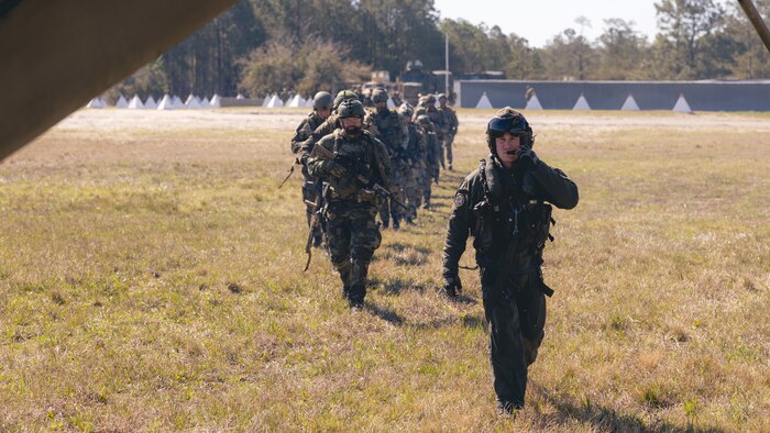 U.S. Marine Corps Staff Sgt. Brandon Mote, crew chief with Marine Heavy Helicopter Squadron-772, 4th Marine Aircraft Wing, Marine Forces Reserve, leads Dutch Marines with Marine Squadron Carib, Netherlands Marine Corps, to a CH-53E Super Stallion for aerial transport in support of exercise Caribbean Urban Warrior on Marine Corps Base Camp Lejeune, N.C., March 28, 2022. The exercise is a bilateral training evolution designed to increase interoperability between U.S. and partner forces.