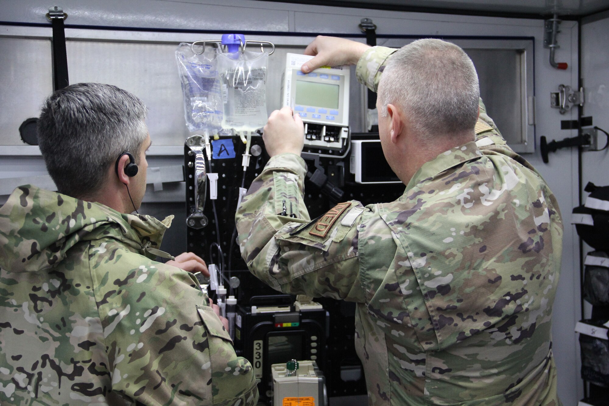 Maj. Thomas Heering, left, an austere anesthesia cadre for the GST, 711th Human Performance Wing, Air Force Research Laboratory, helps Maj. Adam Faltersack, an anesthesia element chief, 81st Surgical Operations Squadron, Keesler Air Force Base, Mississippi, set up prototype A of the tactical anesthesia workstation (TAW), for the first time April 8, 2022, during a Ground Surgical Team (GST), training course at U.S. Air Force School of Aerospace Medicine at Wright-Patterson Air Force Base, Ohio. Heering submitted the TAW idea to Spark Tank in 2021, and the idea moved forward with a team of engineers in the rapid prototyping cell (RPC). The RPC team developed the three prototypes for testing beginning in January 2022, and have since narrowed it down to one winning prototype. The team with push the recommended prototype to the GST pilot group for further deliberation. (U.S. Air Force photo/Aleah Castrejon)