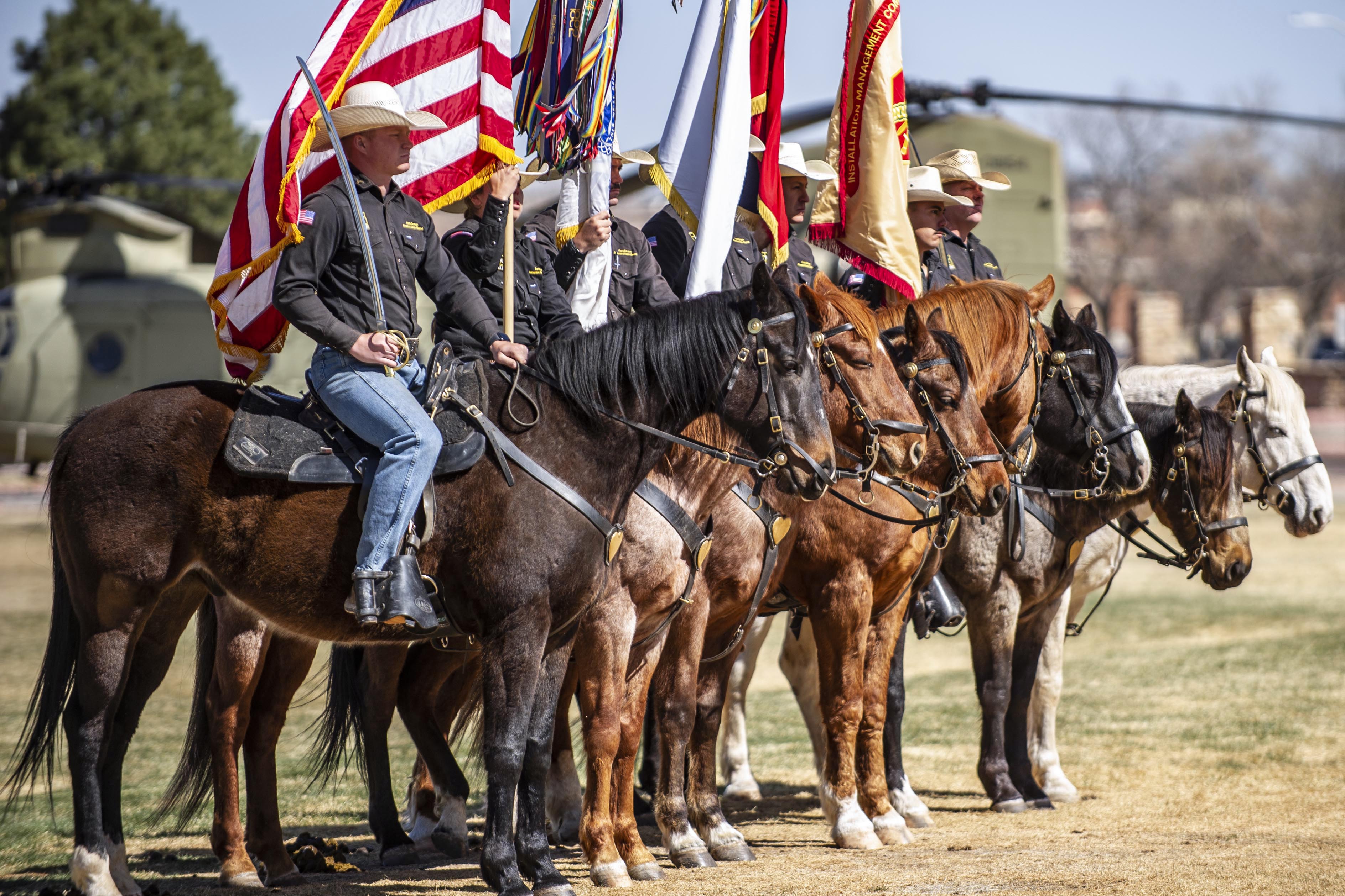 The mounted color guard stands in formation during a ceremony at Fort