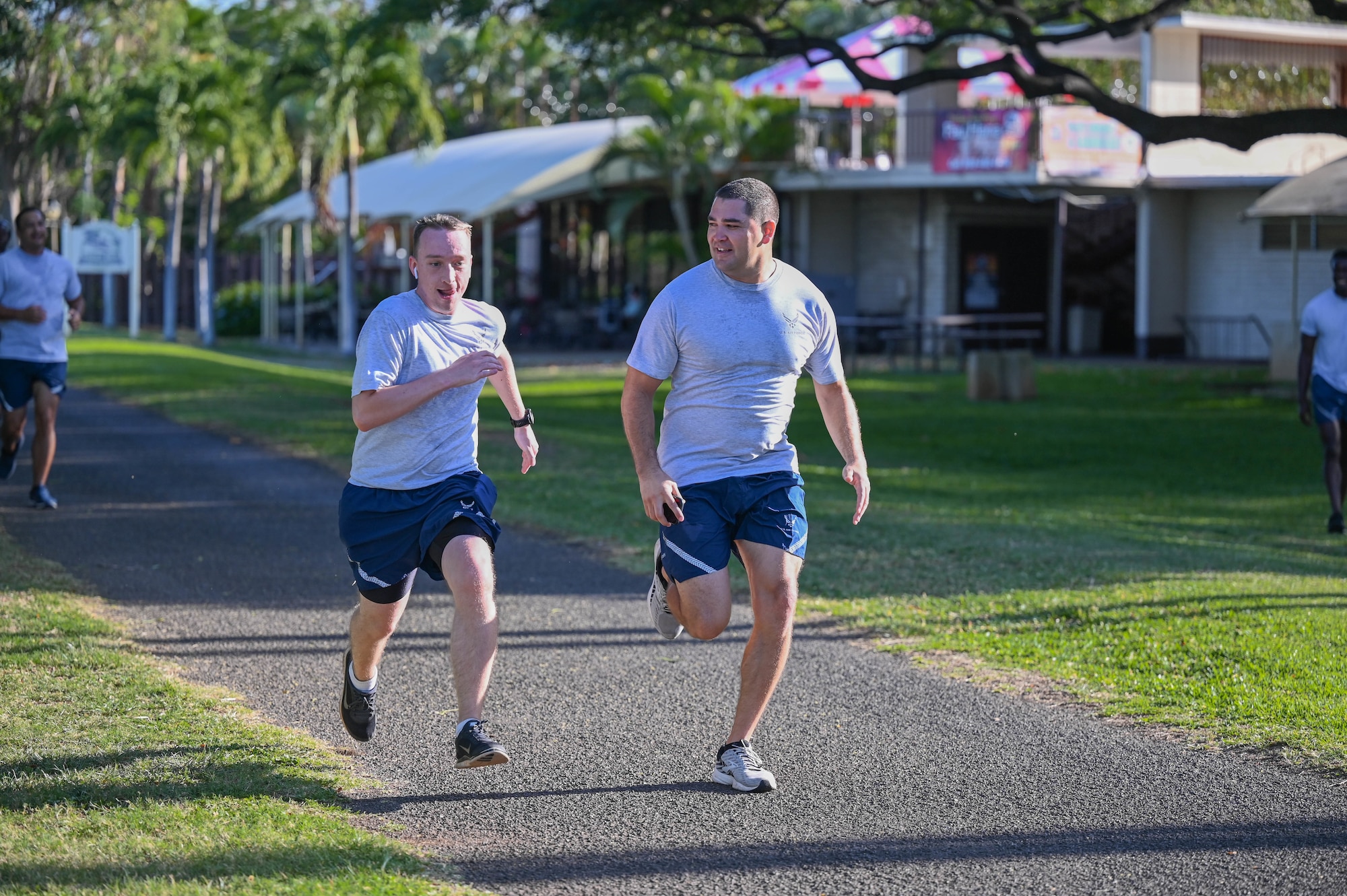Staff Sgt. Corey Easley and Tech. Sgt. Anthony Garcia, Noncomissioned Officer Academy students, race to the finish a school run at Joint Base Pearl Harbor-Hickam, Hawaii, April 14, 2022. The NCOA program focuses on the four areas of culture, leadership, problem solving, and mission to enable NCOs to lead their units and overcome challenges. (U.S. Air Force photo by 1st Lt. Benjamin Aronson)